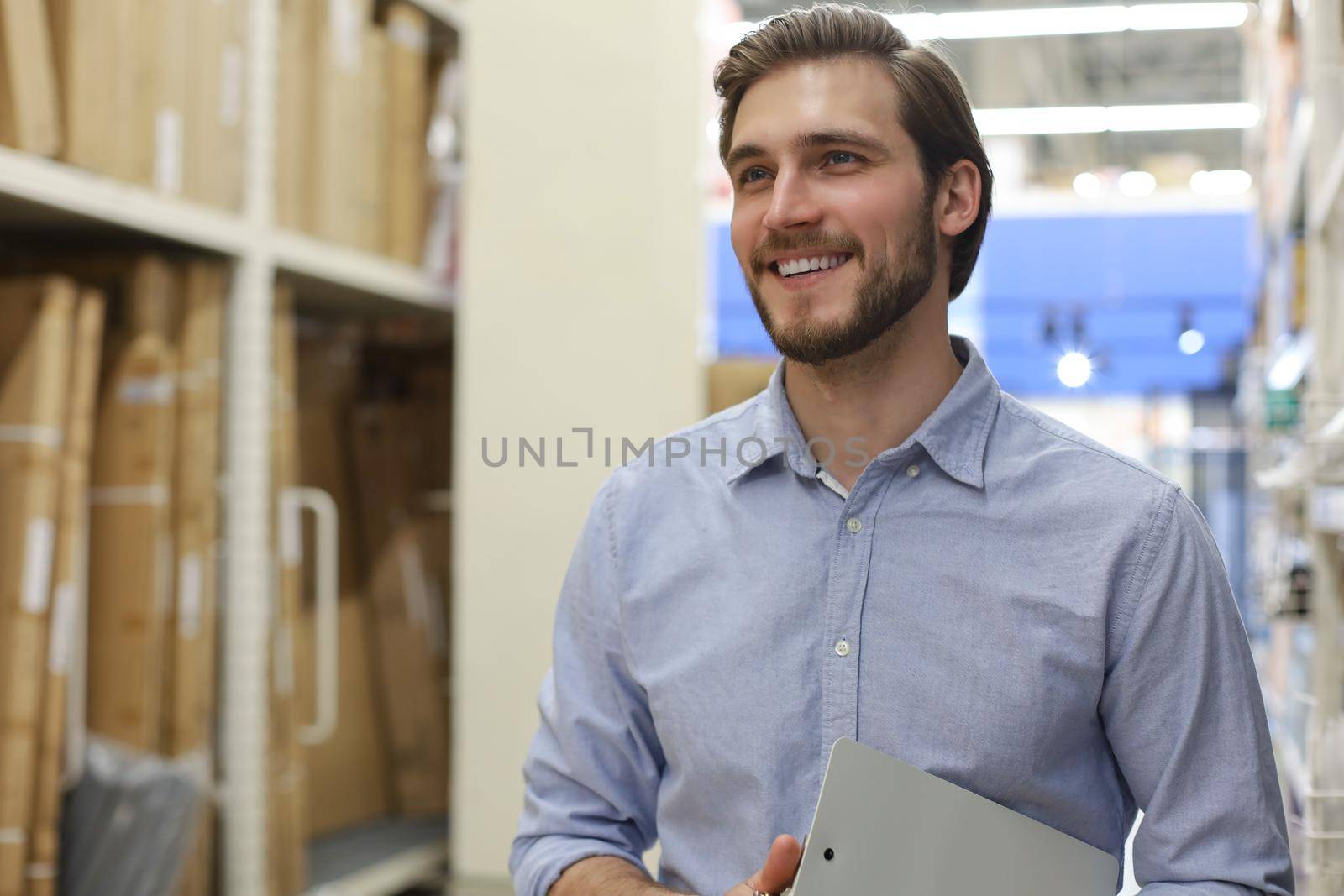 portrait of a smiling young warehouse worker working in a cash and carry wholesale store