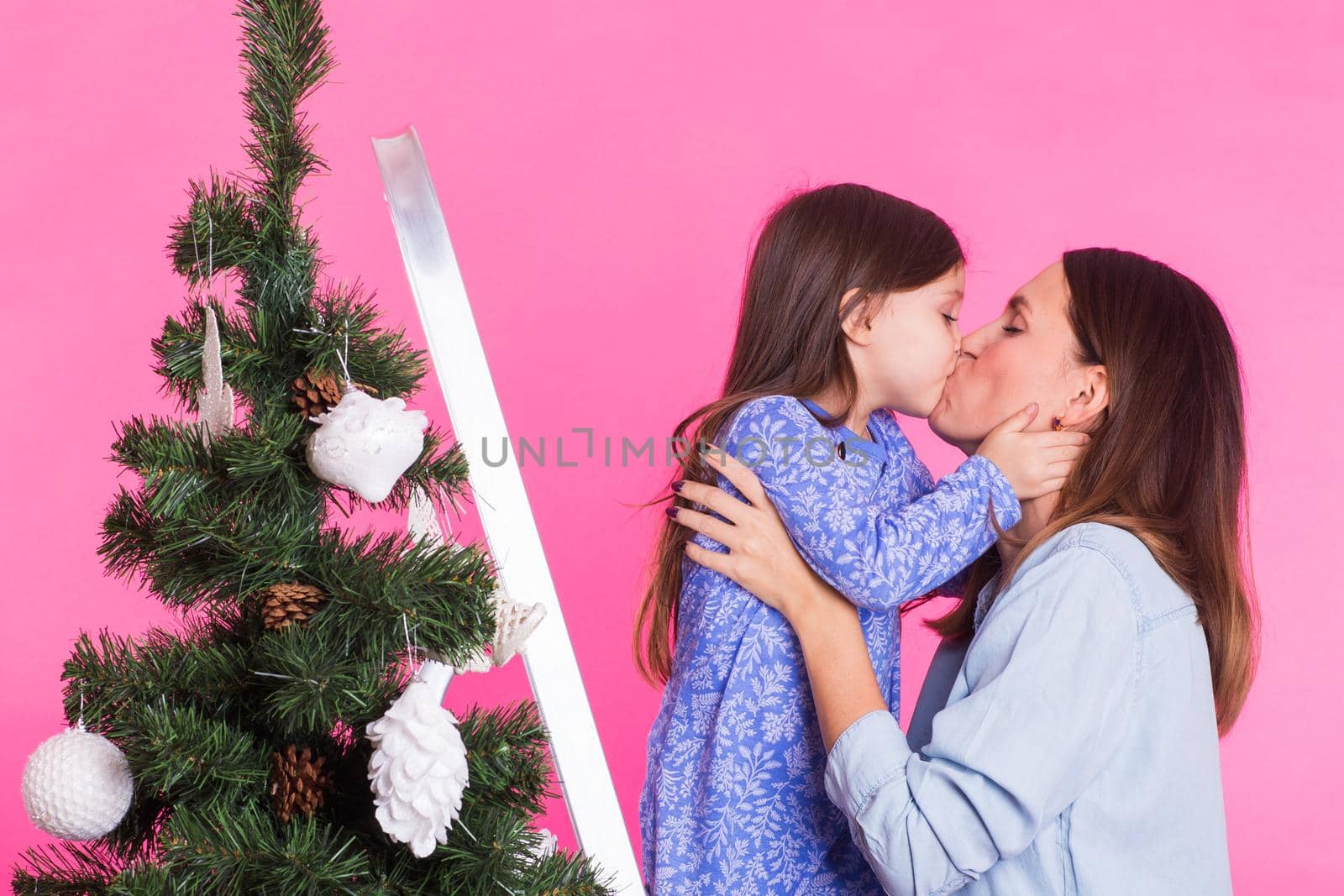 Christmas of young mom and her daughter with Christmas tree on pink background by Satura86