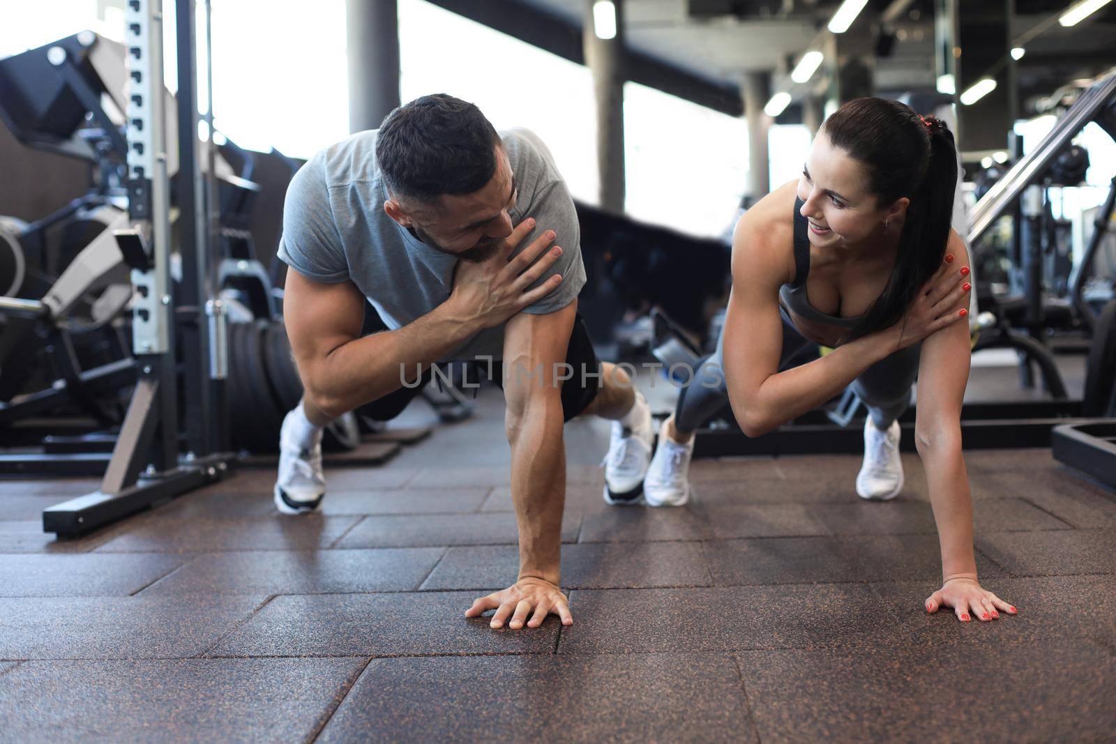 Portrait of beautiful young sports couple on a plank position