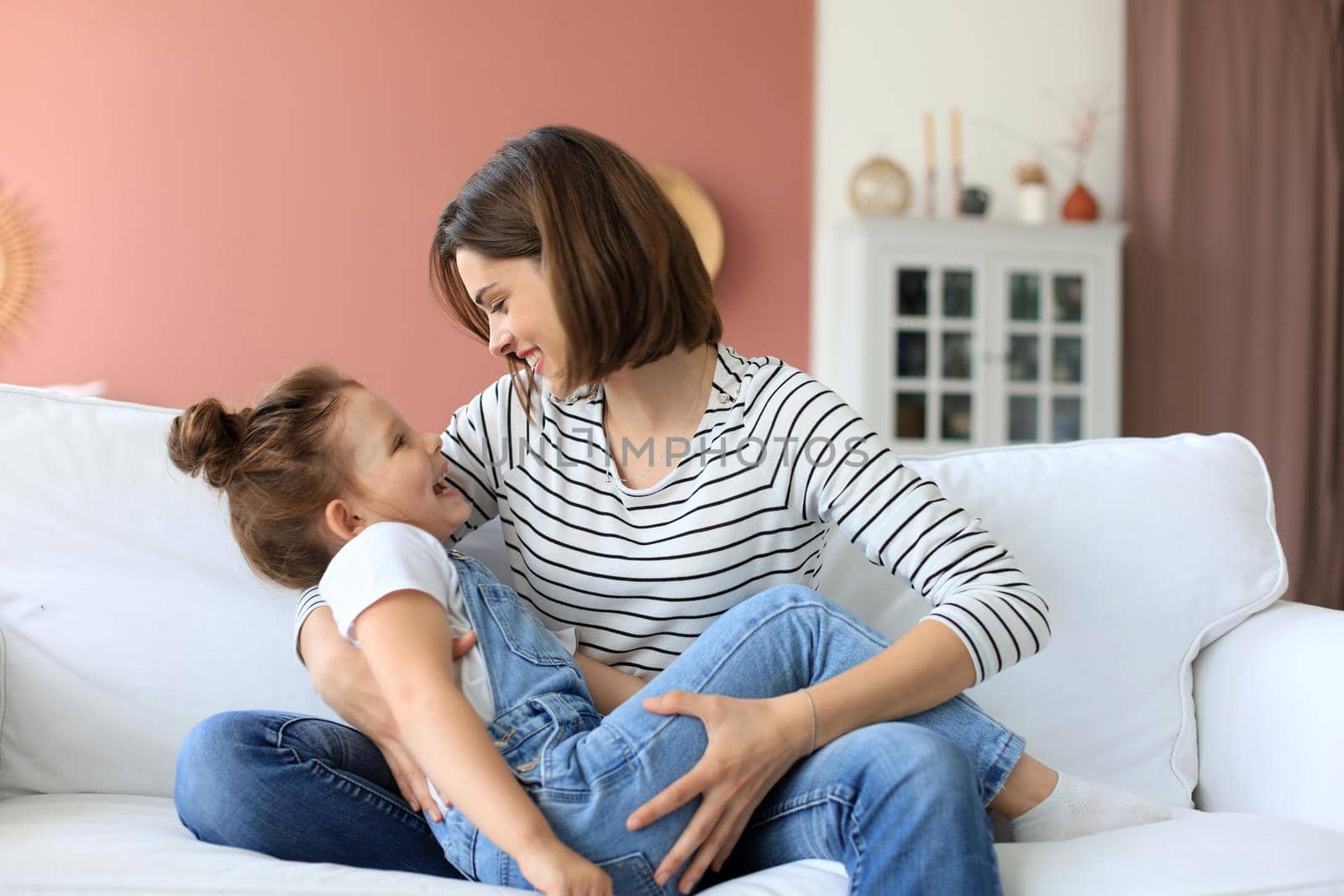 Happy loving mom hugging little daughter, spend time together at home