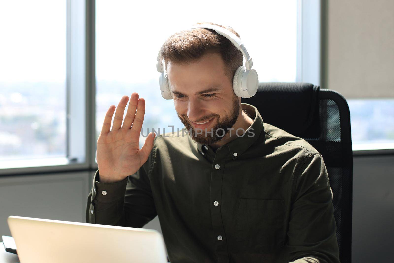 Smiling young business man having video call in office