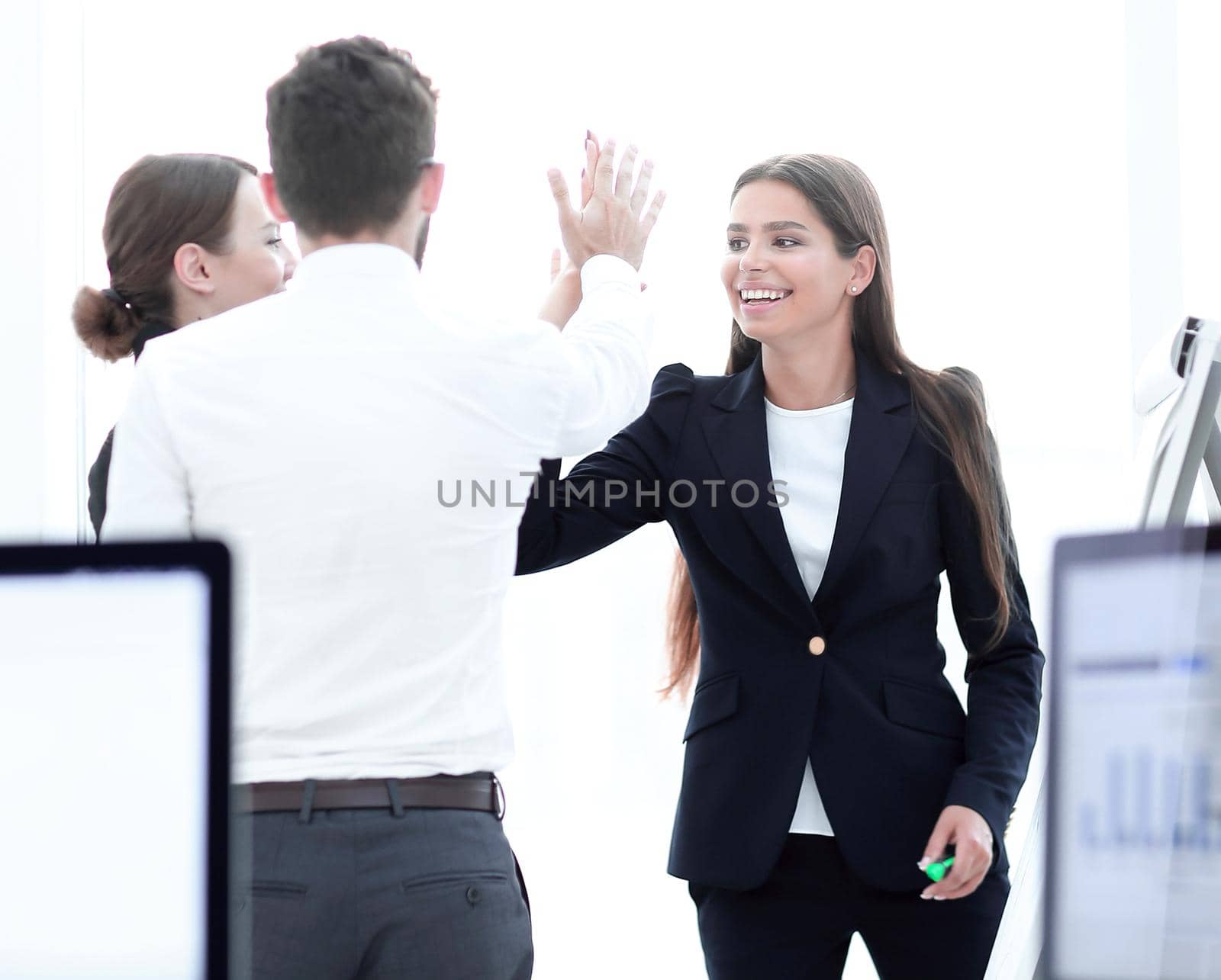 employees giving each other high five. by asdf