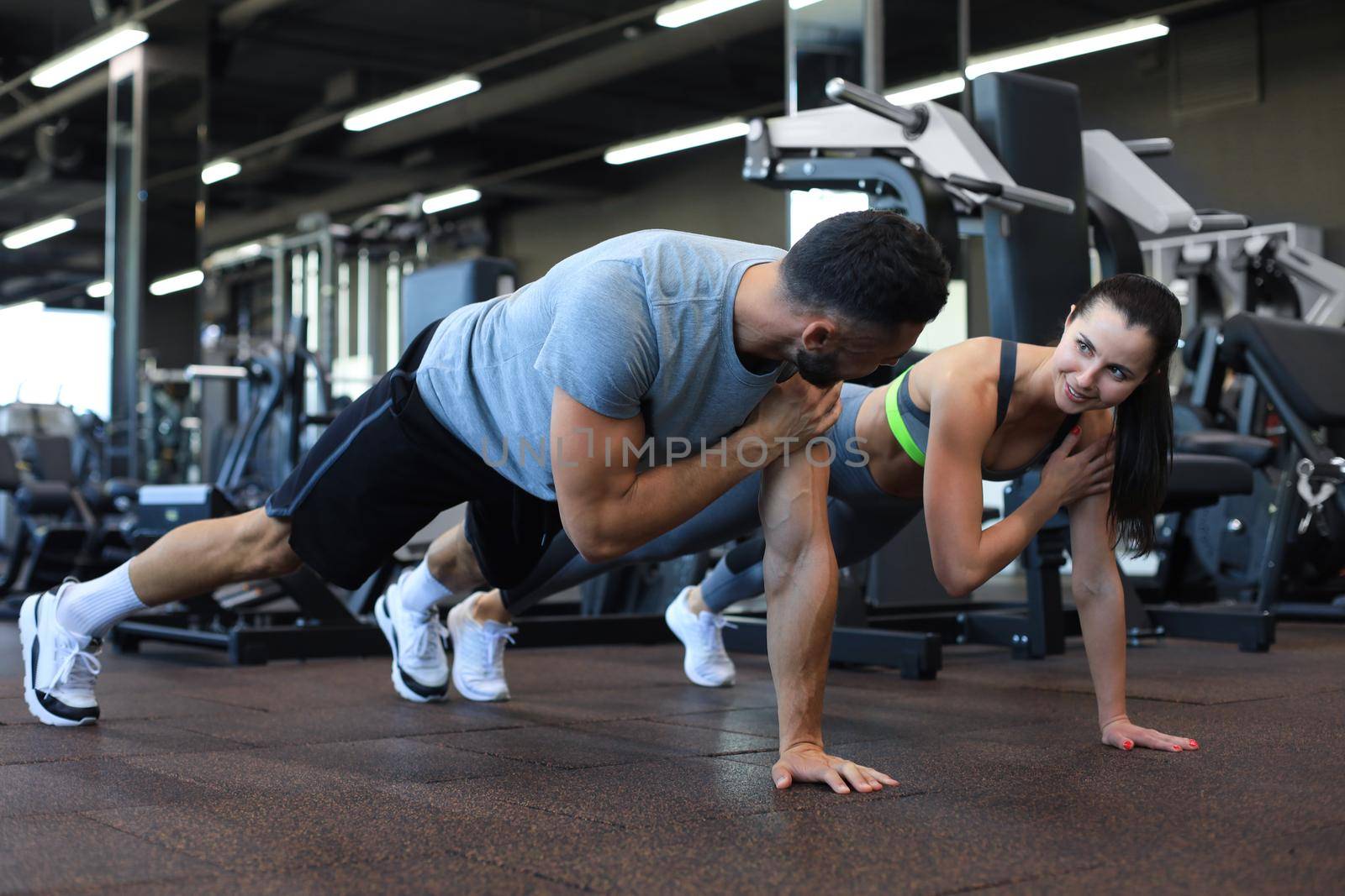 Portrait of beautiful young sports couple on a plank position