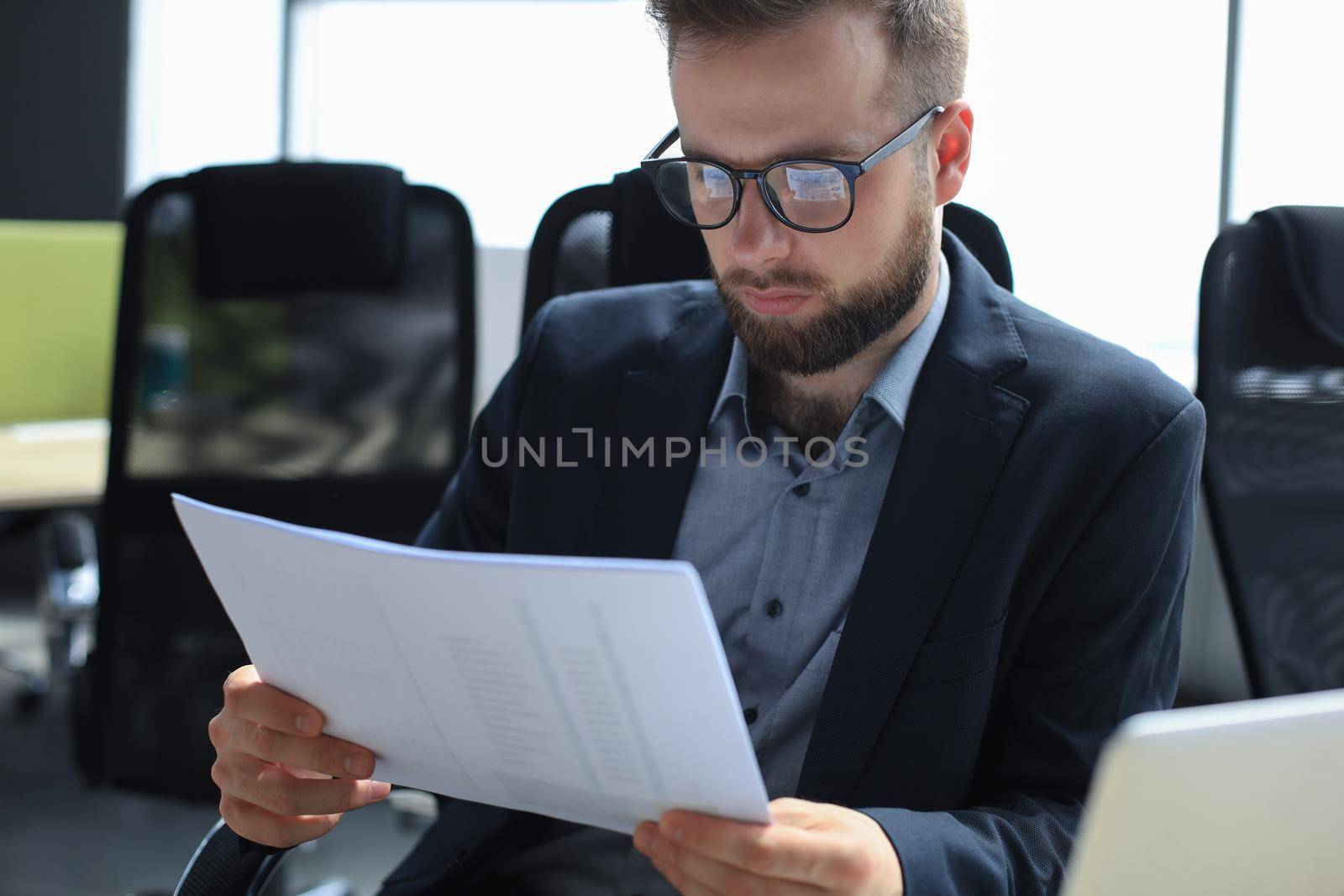 Young man is working with papers while sitting in the office