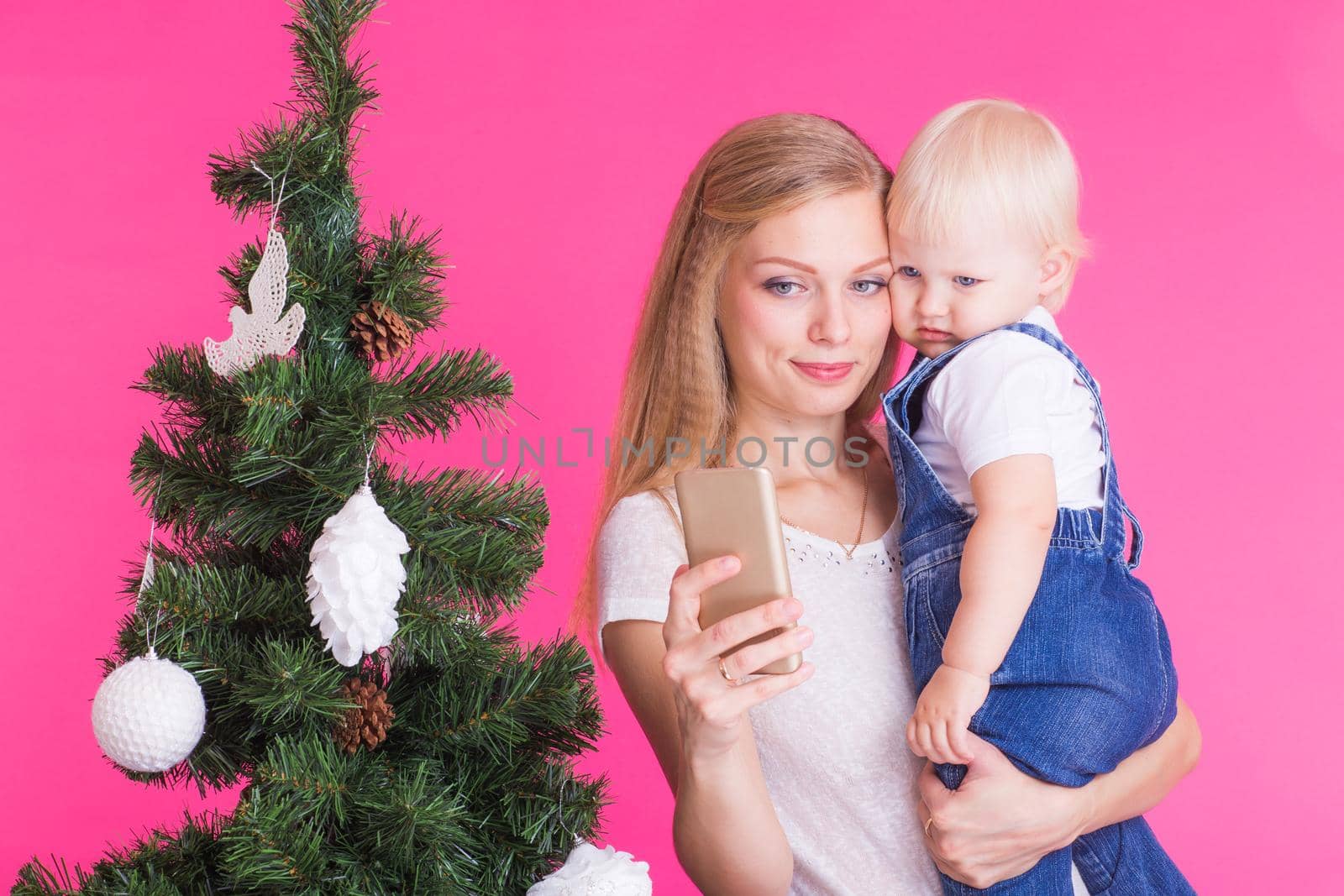 Mother and little daughter taking a selfie near Christmas tree by Satura86