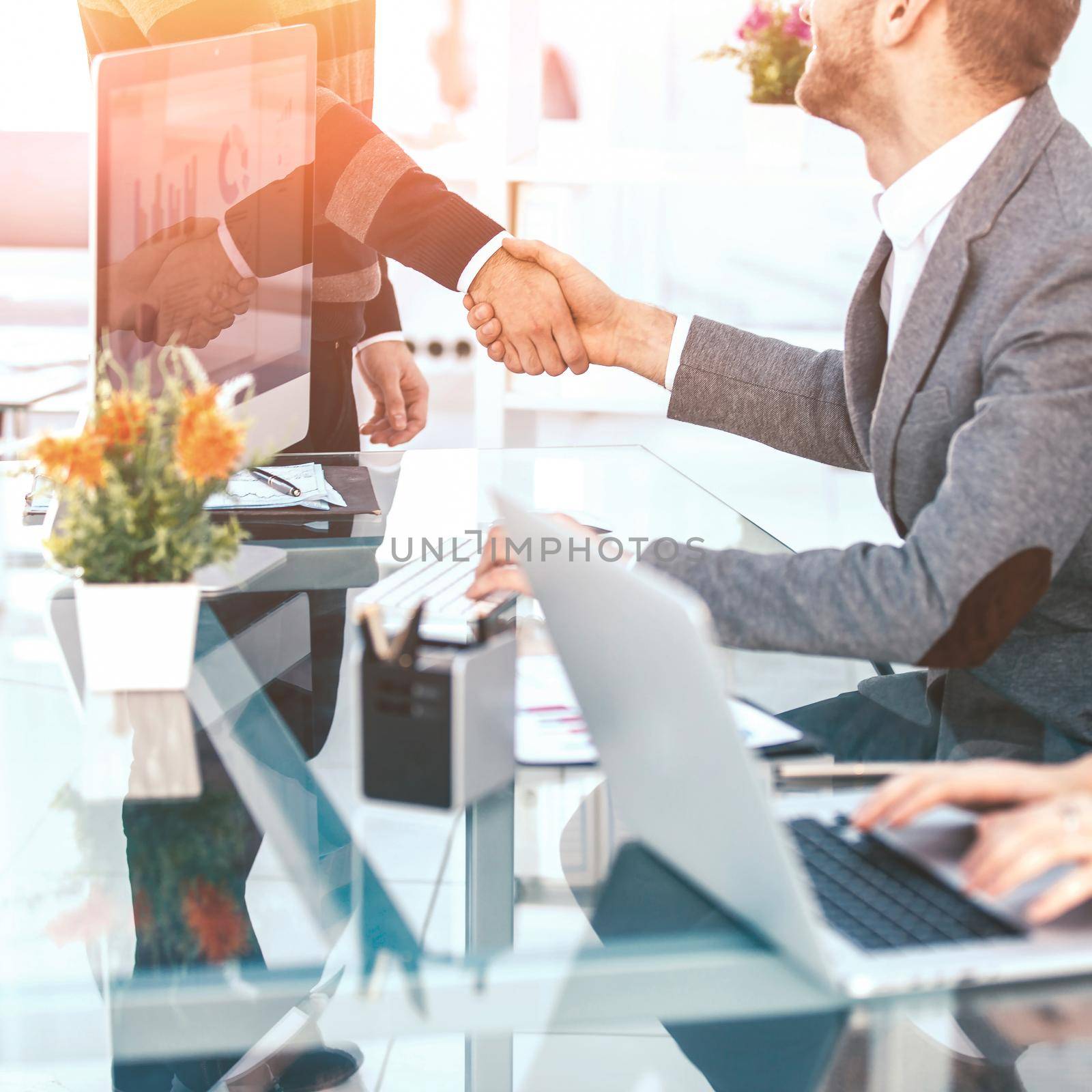handshake of business partners on the background of the desktop .the photo has a empty space for your text.