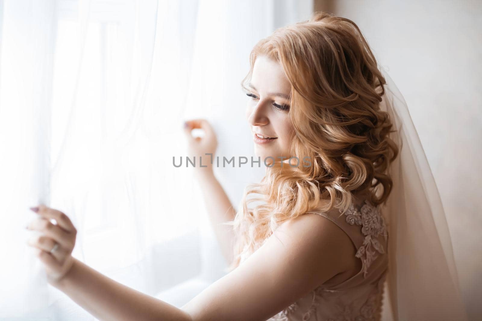 close up. young woman in wedding dress standing near the window. holidays and events
