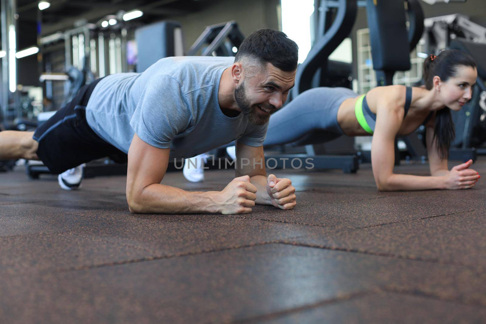 Portrait of beautiful young sports couple on a plank position