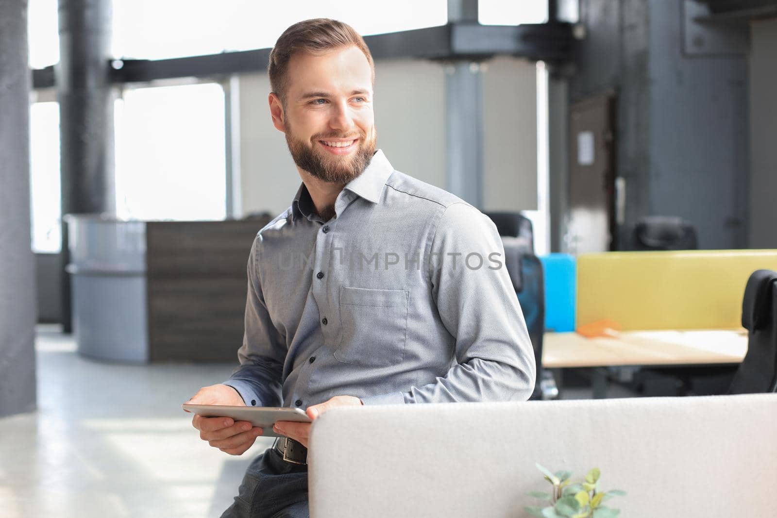 Young businessman using his tablet in the office