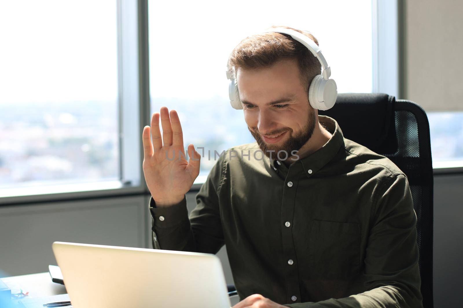 Smiling young business man having video call in office