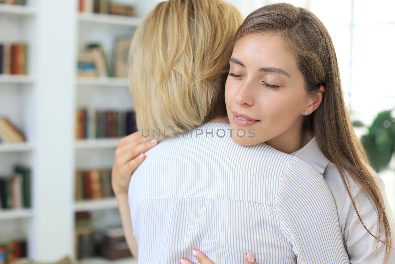 Concerned middle aged mother hugging her adult daughter, listen her anxieties