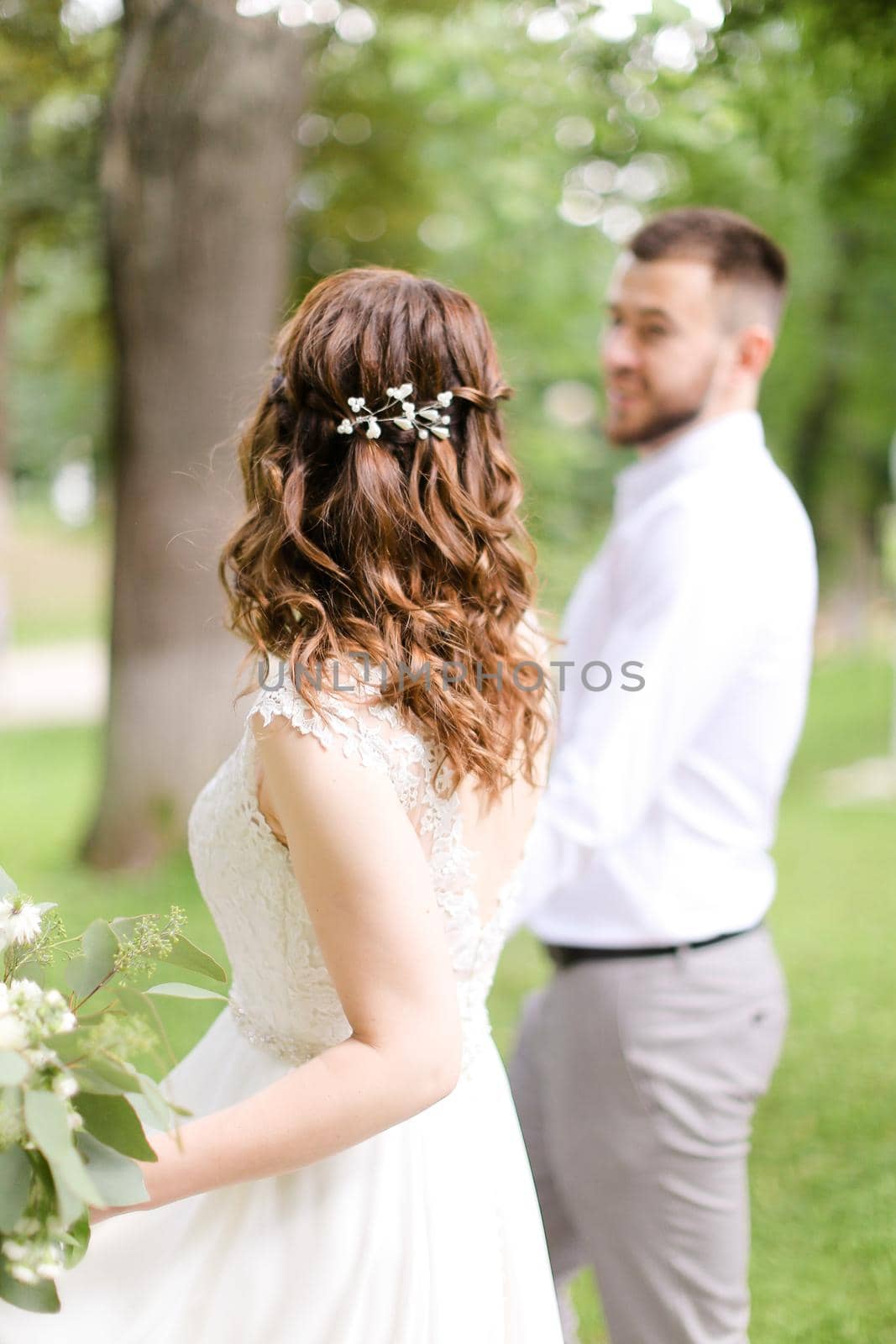 Caucasian happy fiancee walking with groom and bouquet of flowers. Concept of bridal photo session and married couple.