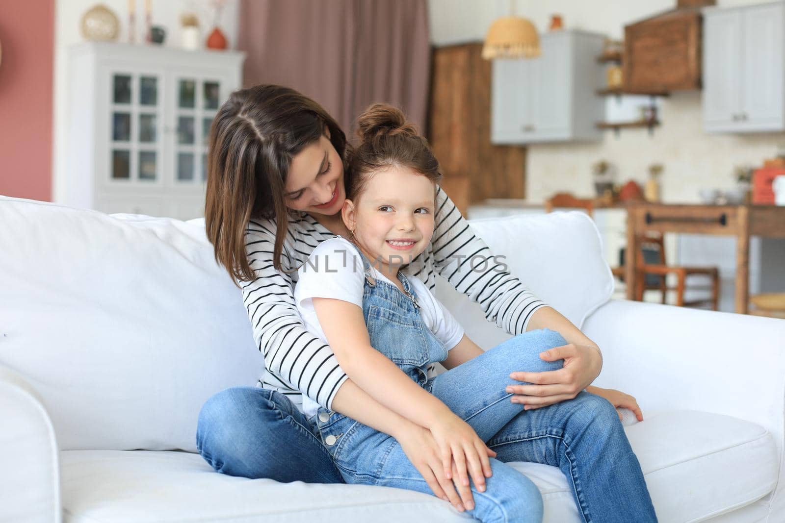 Happy loving mom hugging little daughter, spend time together at home