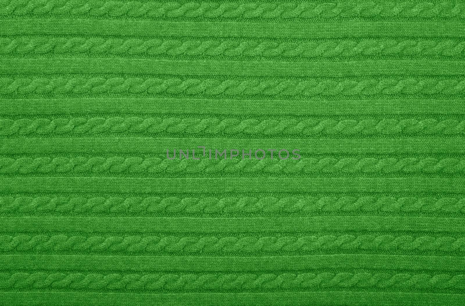 Close up background texture of green cable knitted wool jersey fabric sweater with row braid pattern