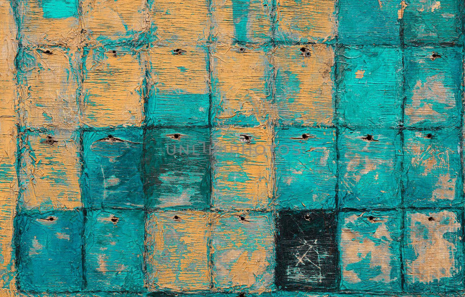 Close up abstract uneven grunge orange yellow and teal blue background with paint peeling off old weathered checkered wooden plywood surface