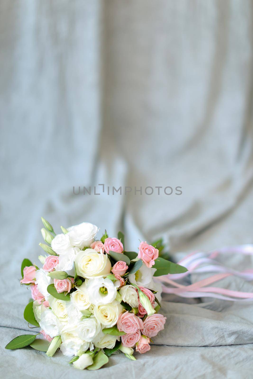 Isolated bouquet of flowers at photo studio in blue background. Concept of floristic art and photo session.