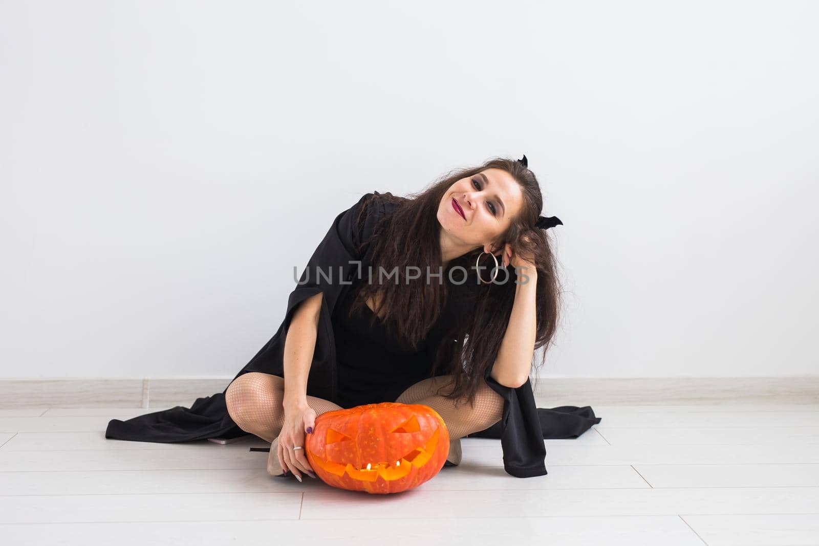 Halloween and holidays concept - Witch woman with Jack O'Lantern pumpkin by Satura86