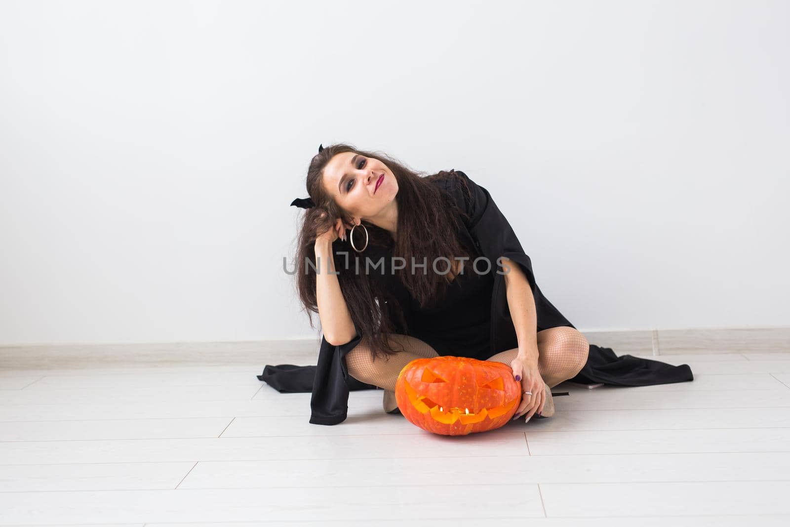Portrait of a style brunette woman with halloween pumpkin