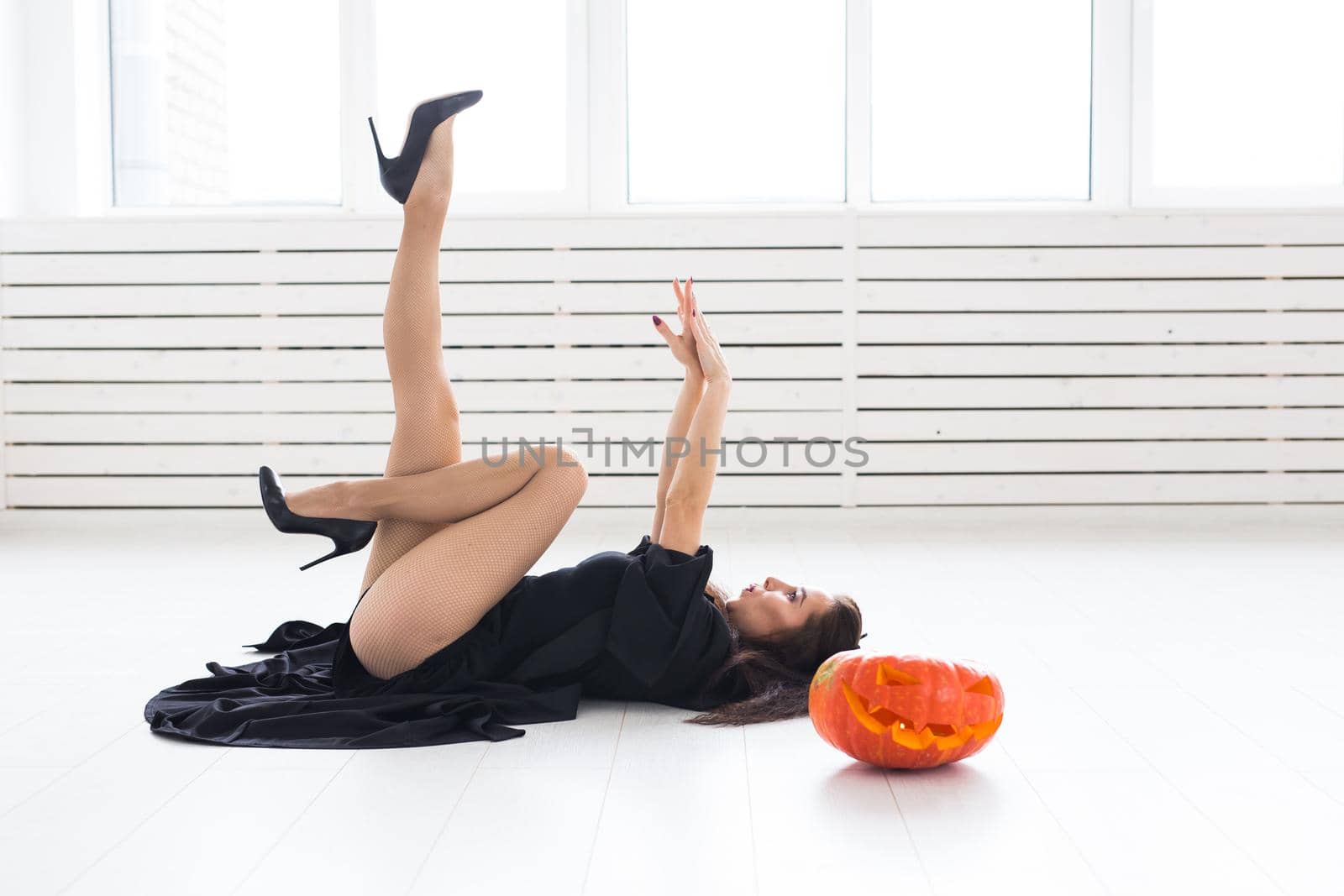 Halloween and holidays concept - Witch woman with Jack O'Lantern pumpkin.