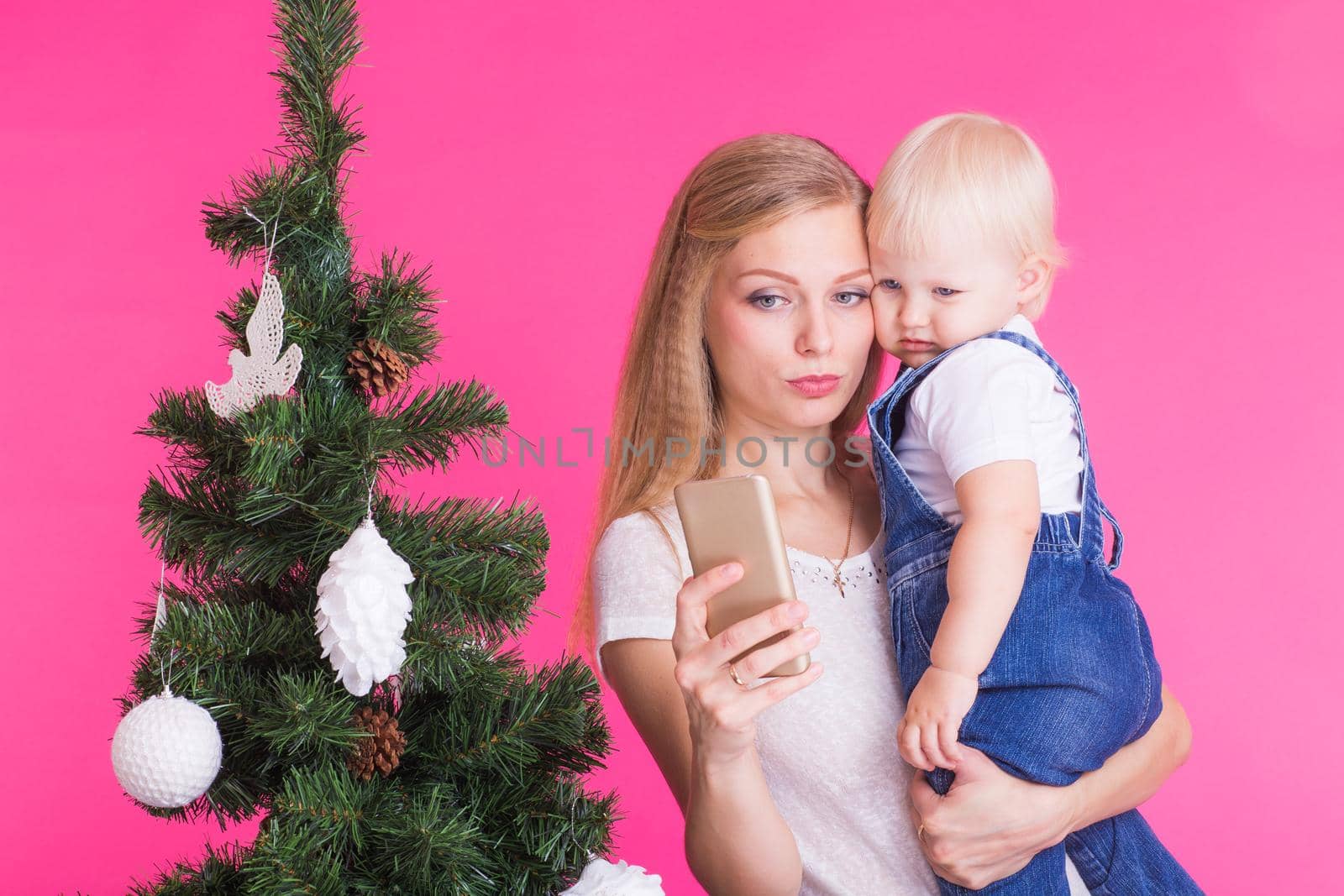 Mother and little daughter taking a selfie near Christmas tree by Satura86