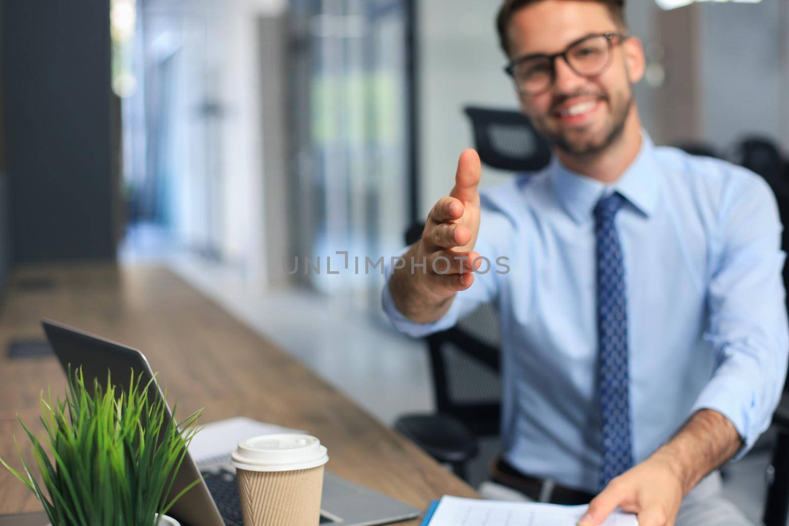 Business man with an open hand ready to seal a deal in office