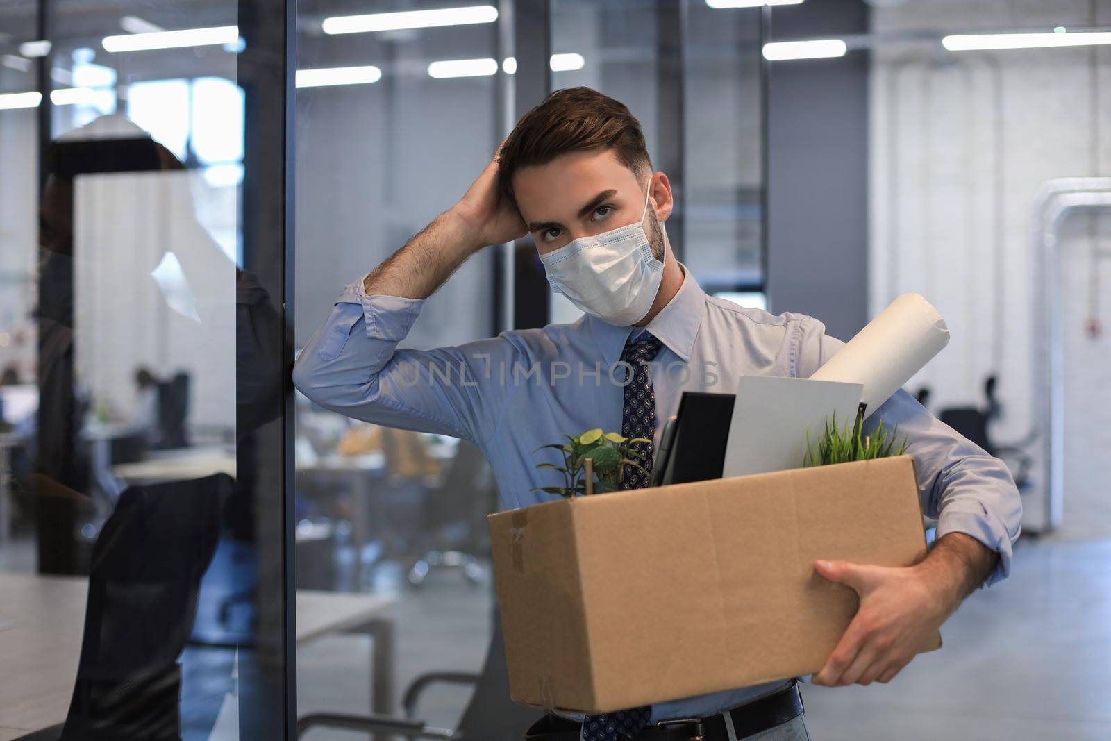 Dismissal employee in an epidemic coronavirus. Dismissed worker going from the office with his office supplies