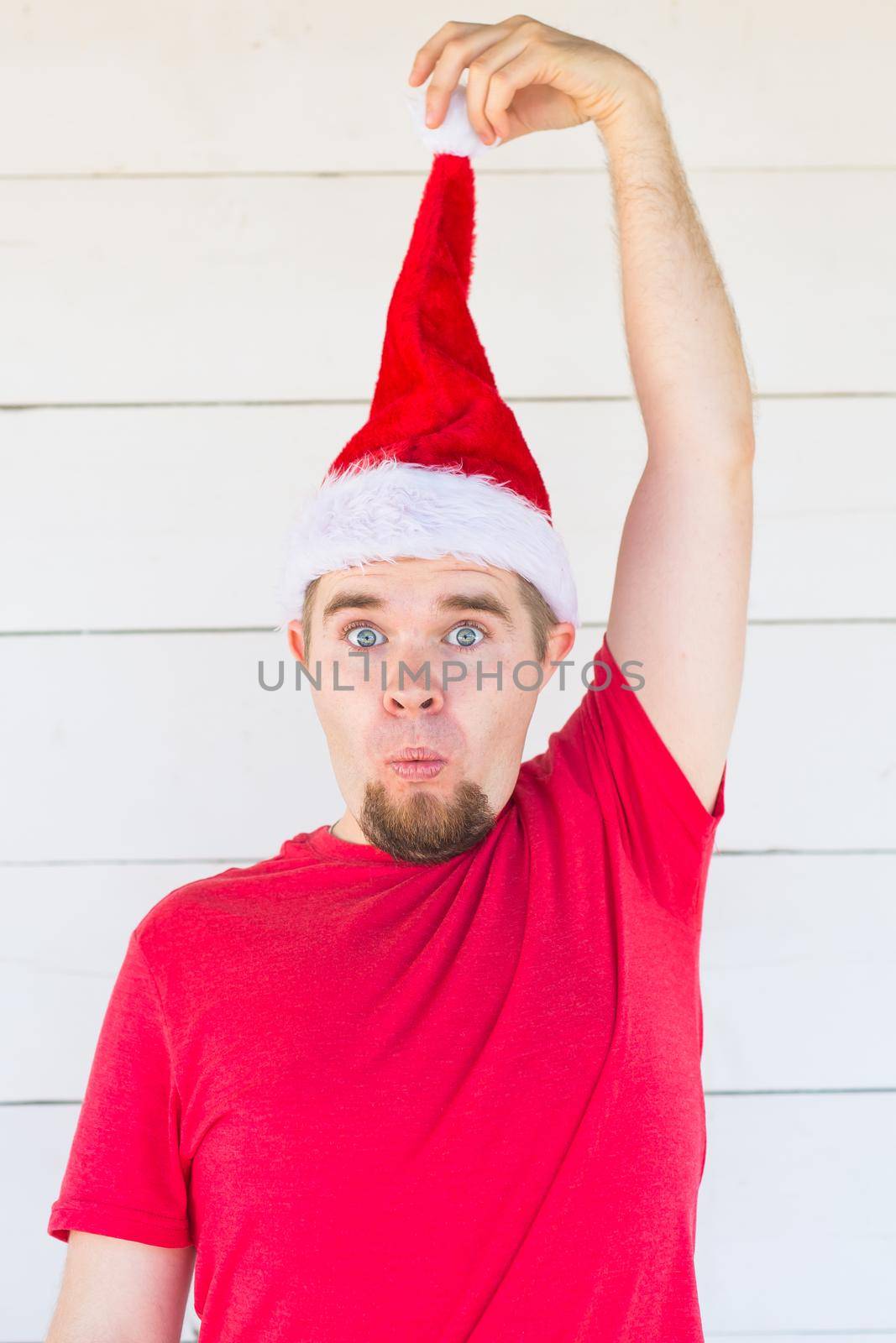 Holidays, christmas and clothing concept - surprised funny man in santa costume posing on white background by Satura86