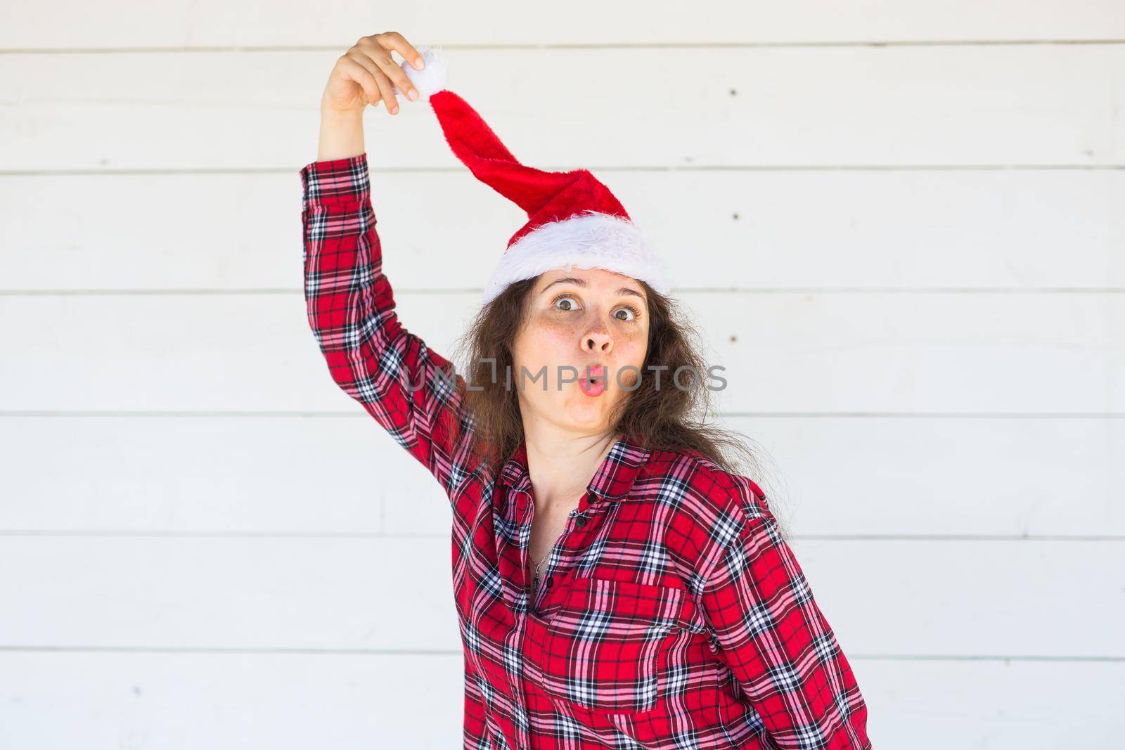 Holidays, christmas and clothing concept - funny woman in santa costume posing on white background by Satura86