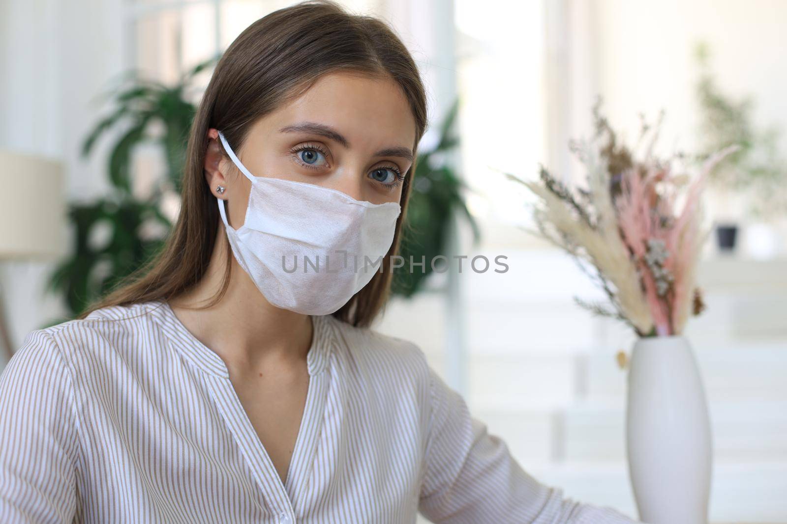Young woman in medical mask at home during epidemic situation