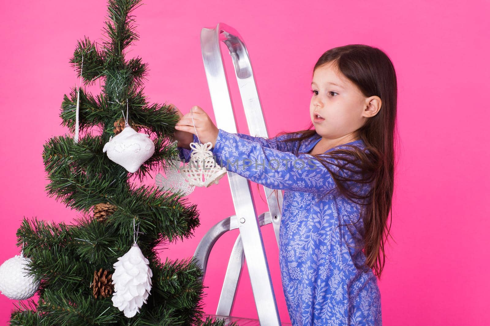 Christmas, childhood and people concept - little girl standing on step-ladder decorating the christmas tree by Satura86