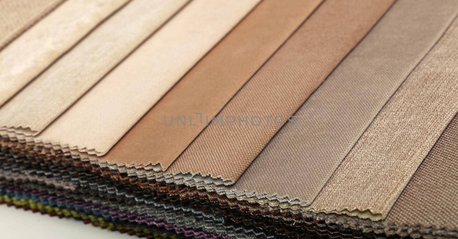 Colorful beige and brown fabric samples swatch in textile catalogue palette, selection of different colors and textures range to choose for interior design and furniture decoration