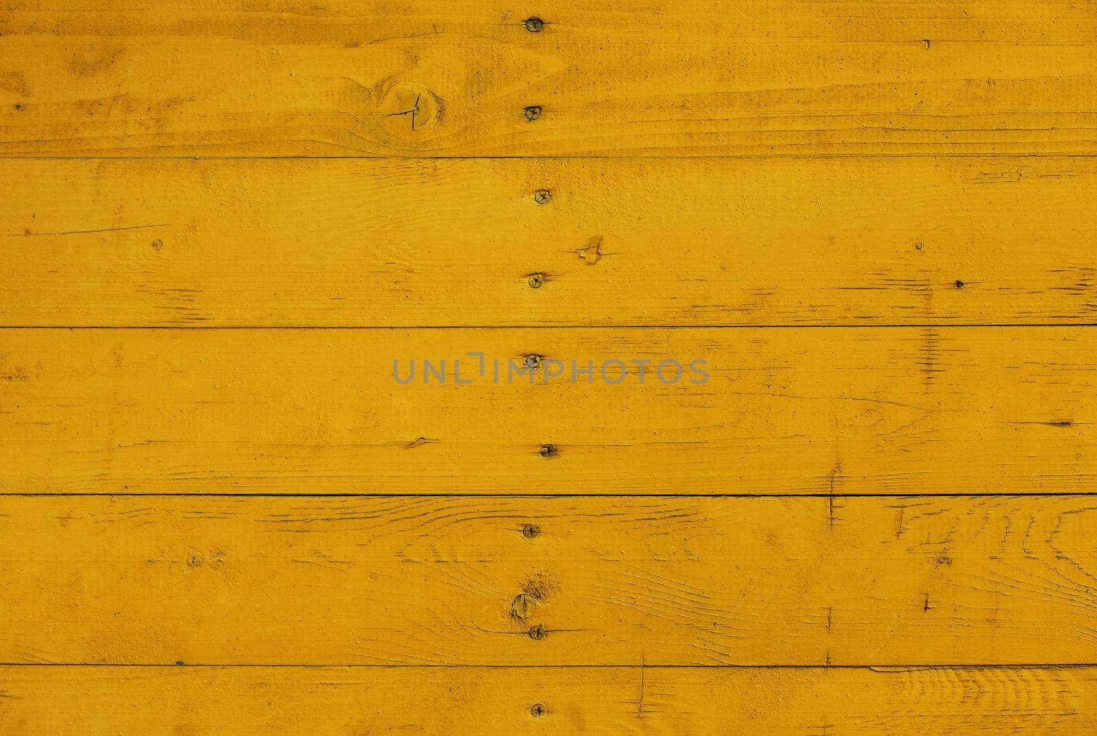 Close up background texture of warm yellow vintage weathered painted wooden planks, rustic style wall panel