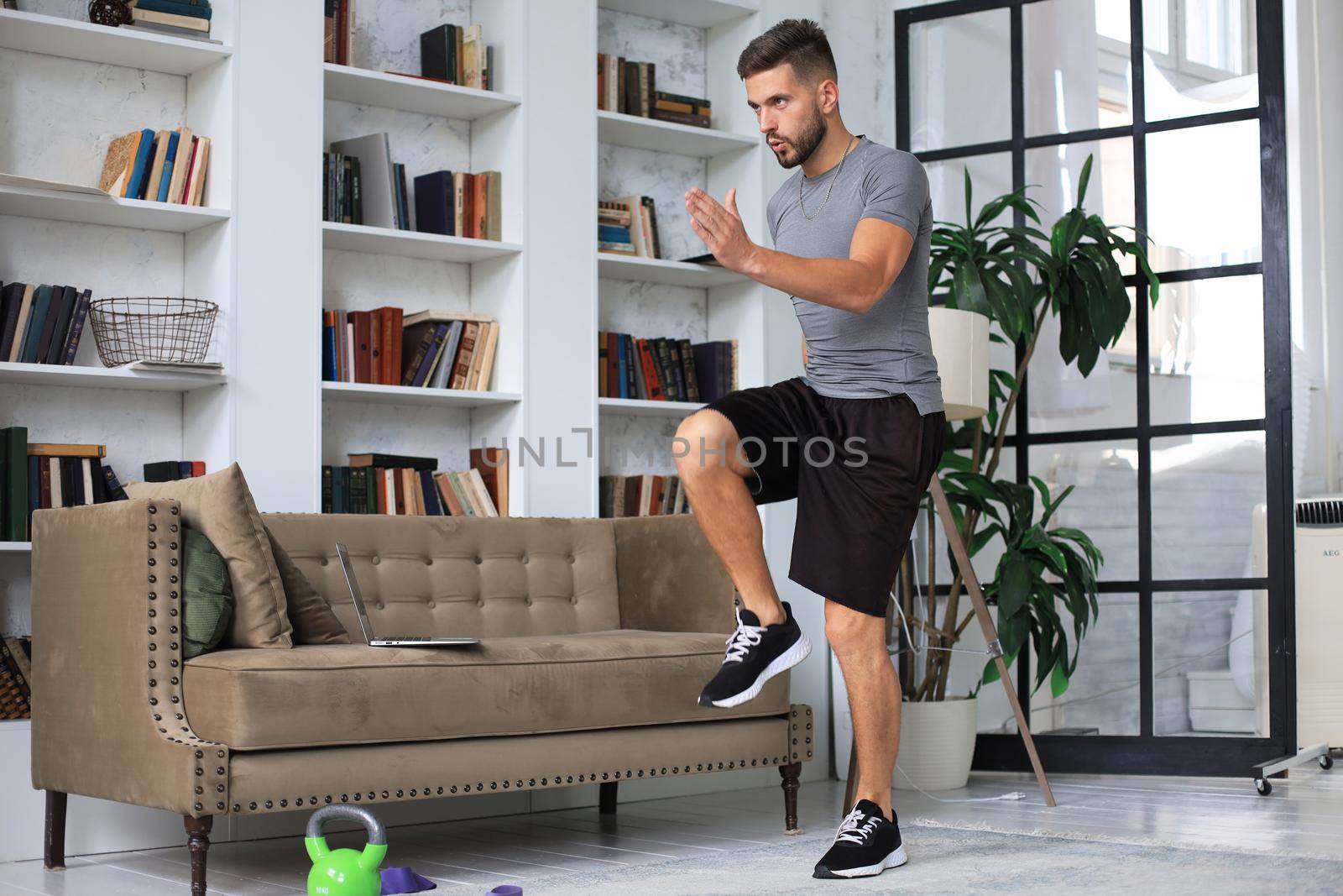 Handsome man doing sport exercise at home during quarantine. Concept of healthy life