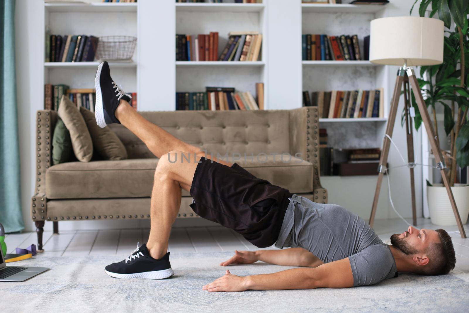 Handsome man doing sport exercise at home during quarantine. Concept of healthy life