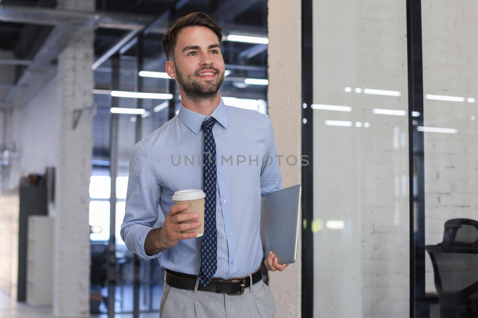 Young handsome businessman smiling in an office environment