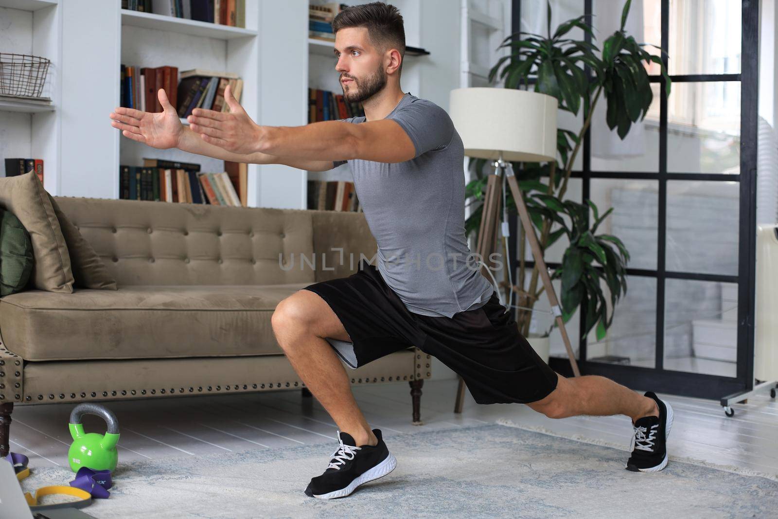 Handsome man doing sport exercise at home during quarantine. Concept of healthy life