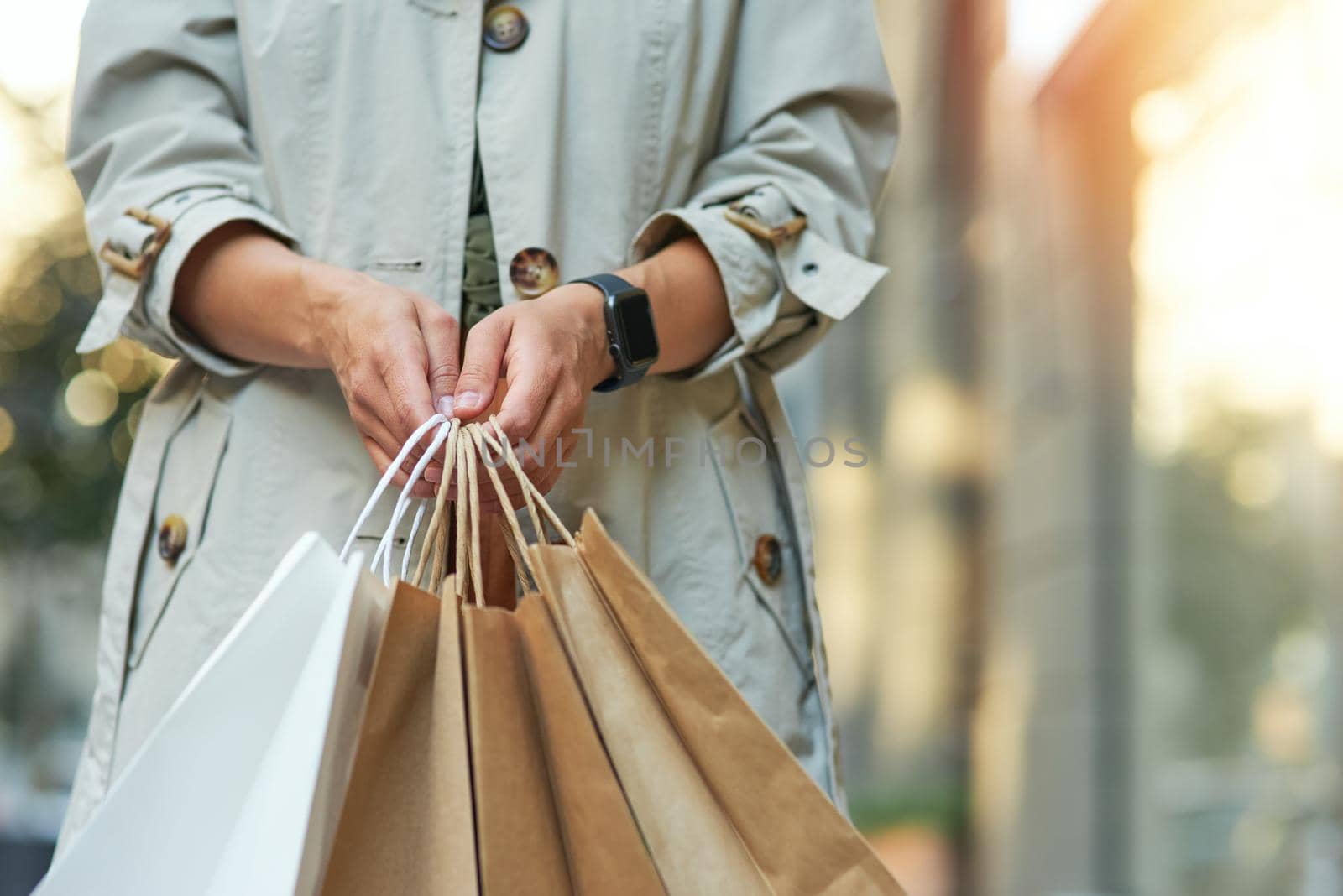 Cropped shot of a woman with shopping bags standing outdoors. Shopaholism, sale, people lifestyle