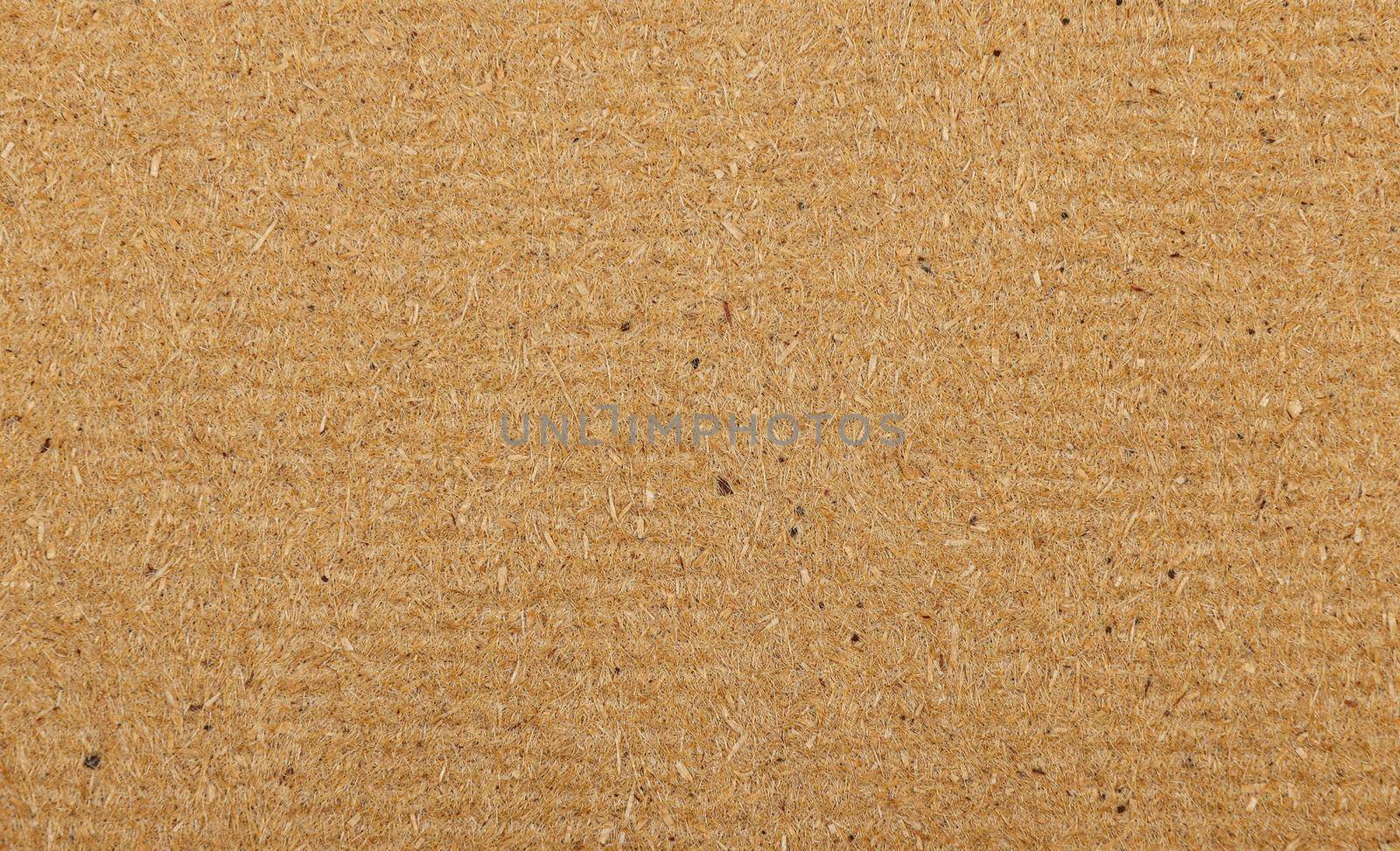 Close up background texture of unpainted natural brown wooden fiberboard plate, sheet construction material also used for furniture production