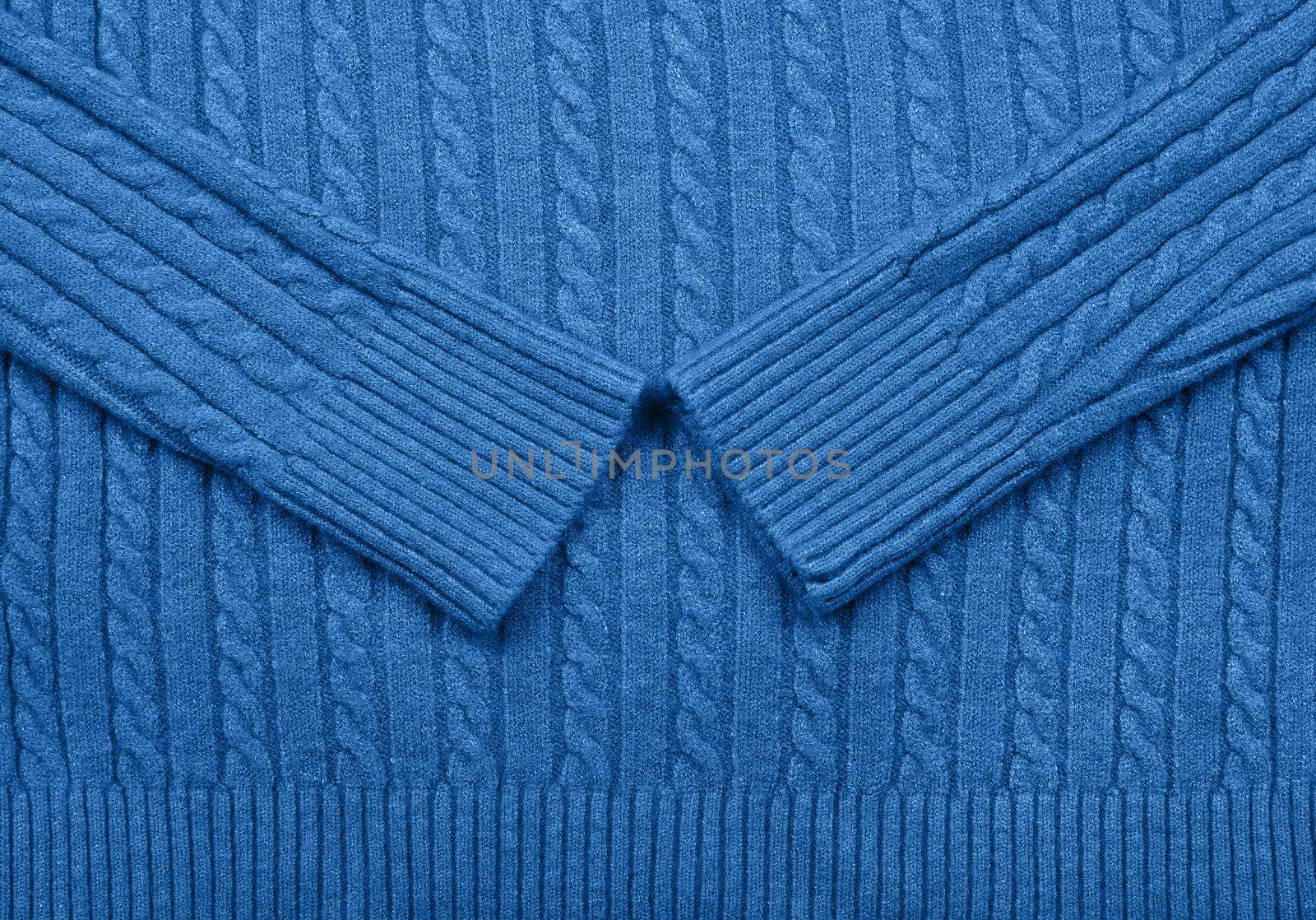 Close up background texture of blue cable knitted wool jersey fabric sweater with row braid pattern