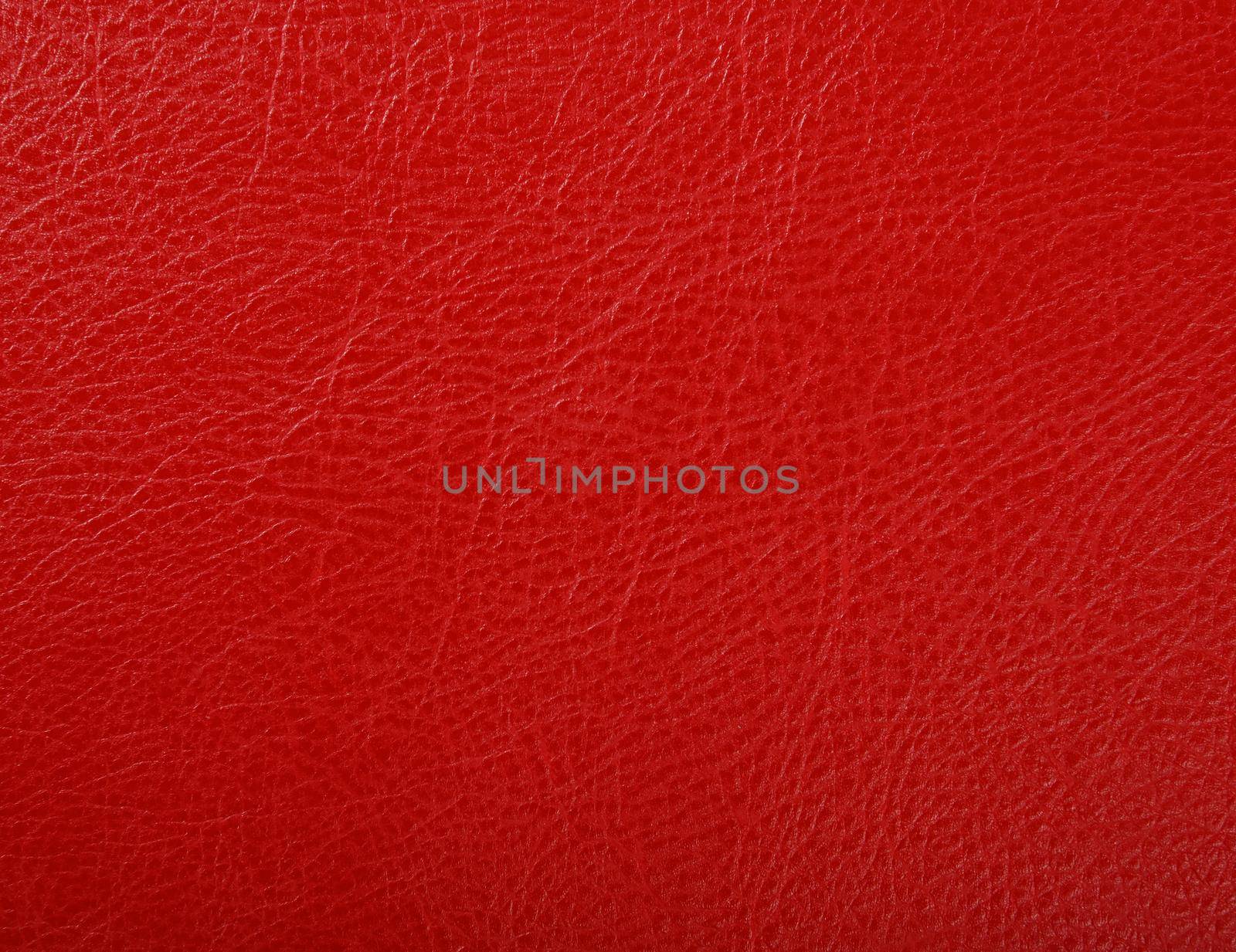 Close up background texture pattern of scarlet red natural leather grain, directly above