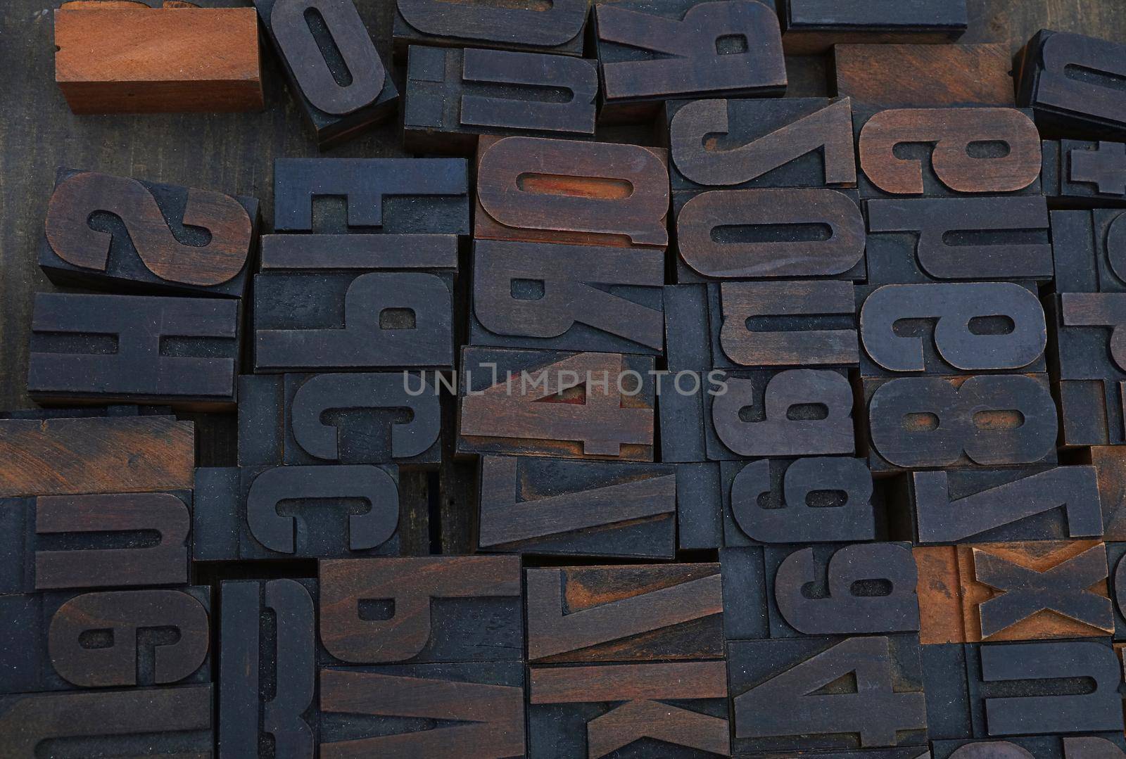 Old dark wooden vintage antique offset typography letterpress printing blocks grunge dirty with paint, mixed alphabet, close up, high angle view