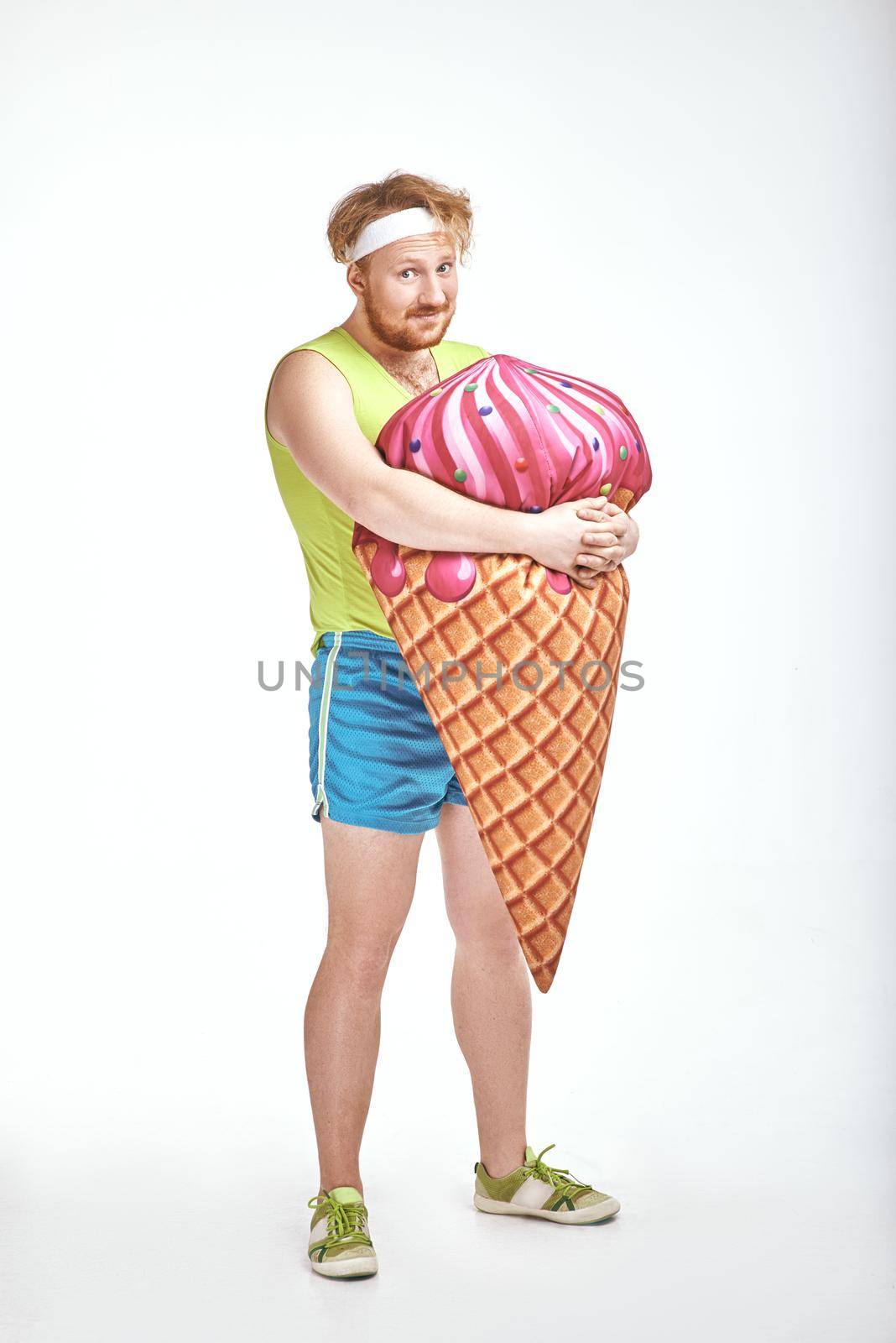 Red haired, bearded, plump man is holding a big ice cream by friendsstock