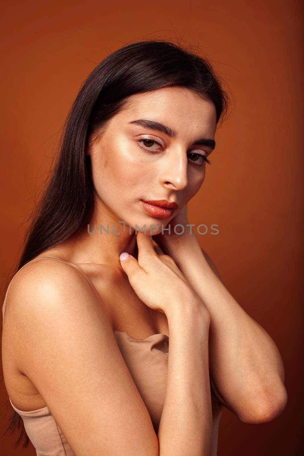 cute happy young indian woman in studio closeup smiling on brown background, fashion beauty lifestyle people concept by JordanJ