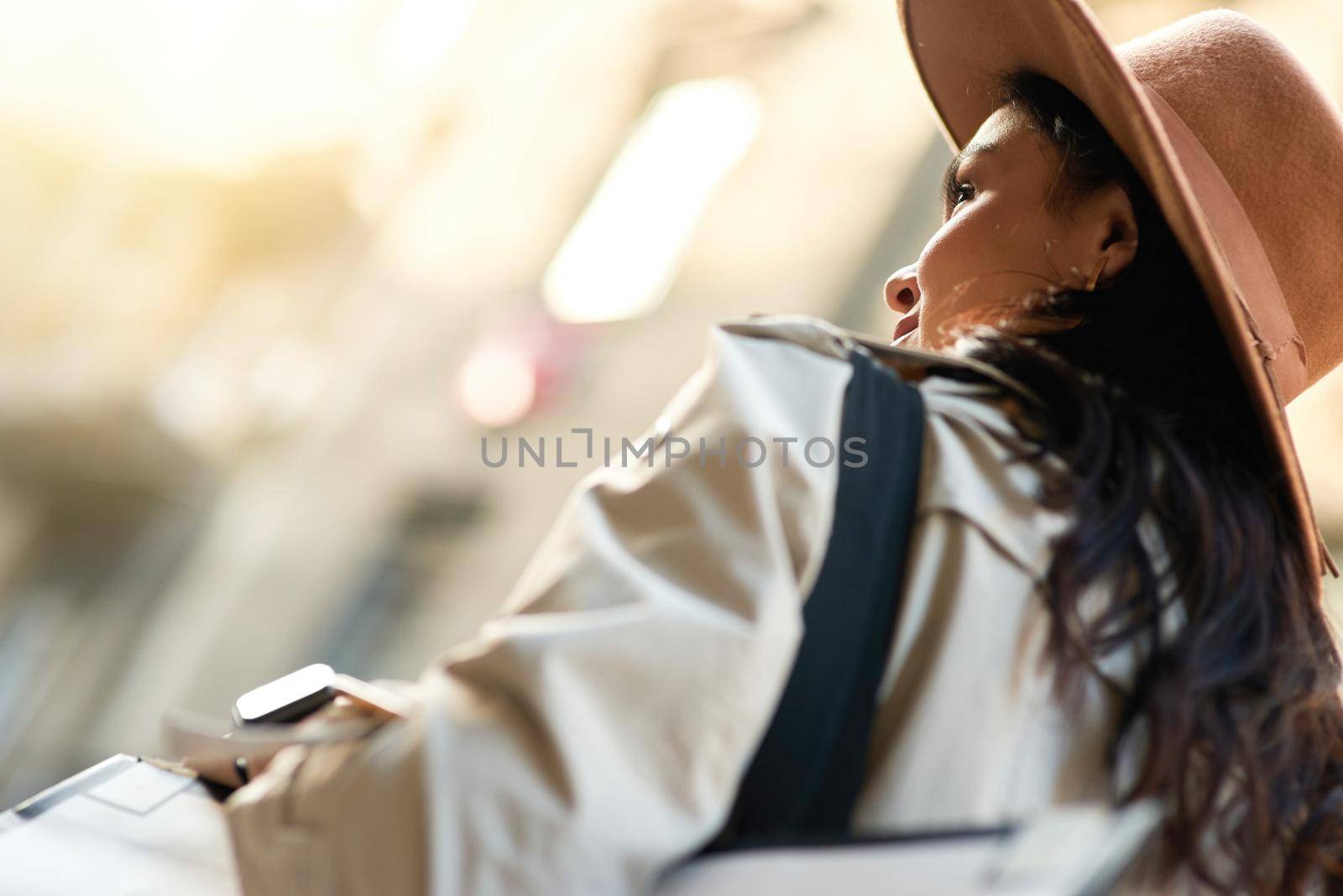 Shopping day. Rear view of a stylish caucasian woman wearing hat walking city streets by friendsstock