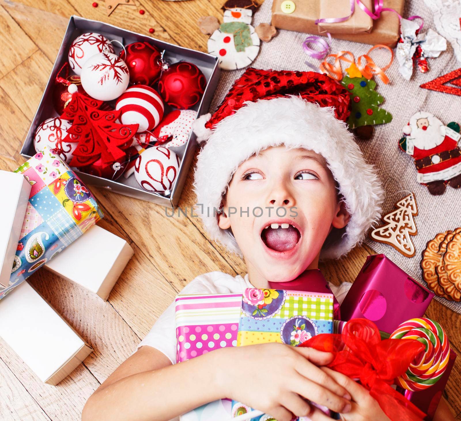 little cute boy with Christmas gifts at home. close up emotional happy smiling in mess with toys, lifestyle holiday real people concept by JordanJ