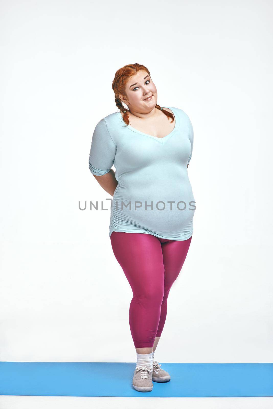 Funny, amusing, red haired, chubby woman is shy by friendsstock