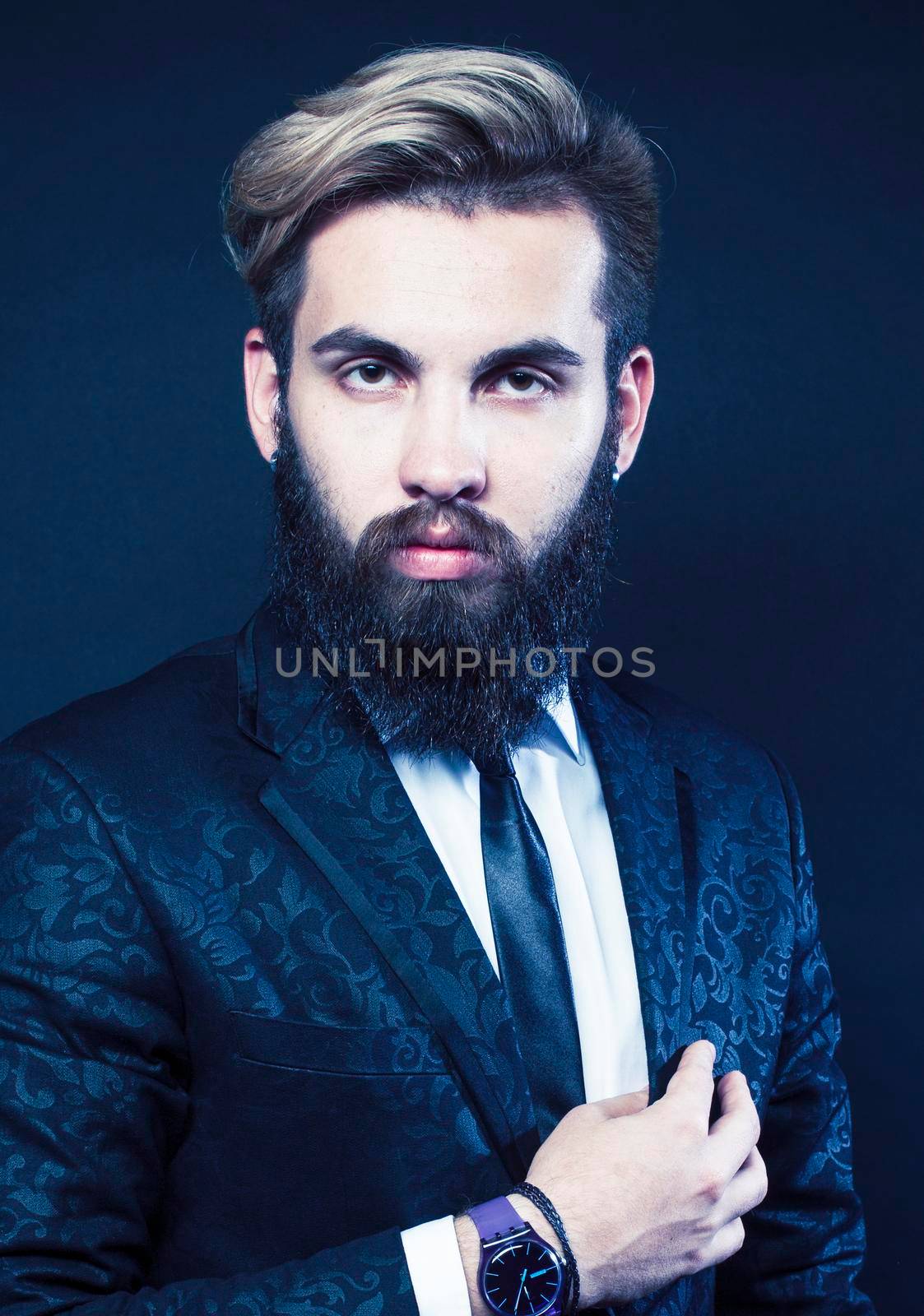 portrait of young bearded hipster guy on gray dark background close up, brutal modern man in suit, lifestyle people concept close up