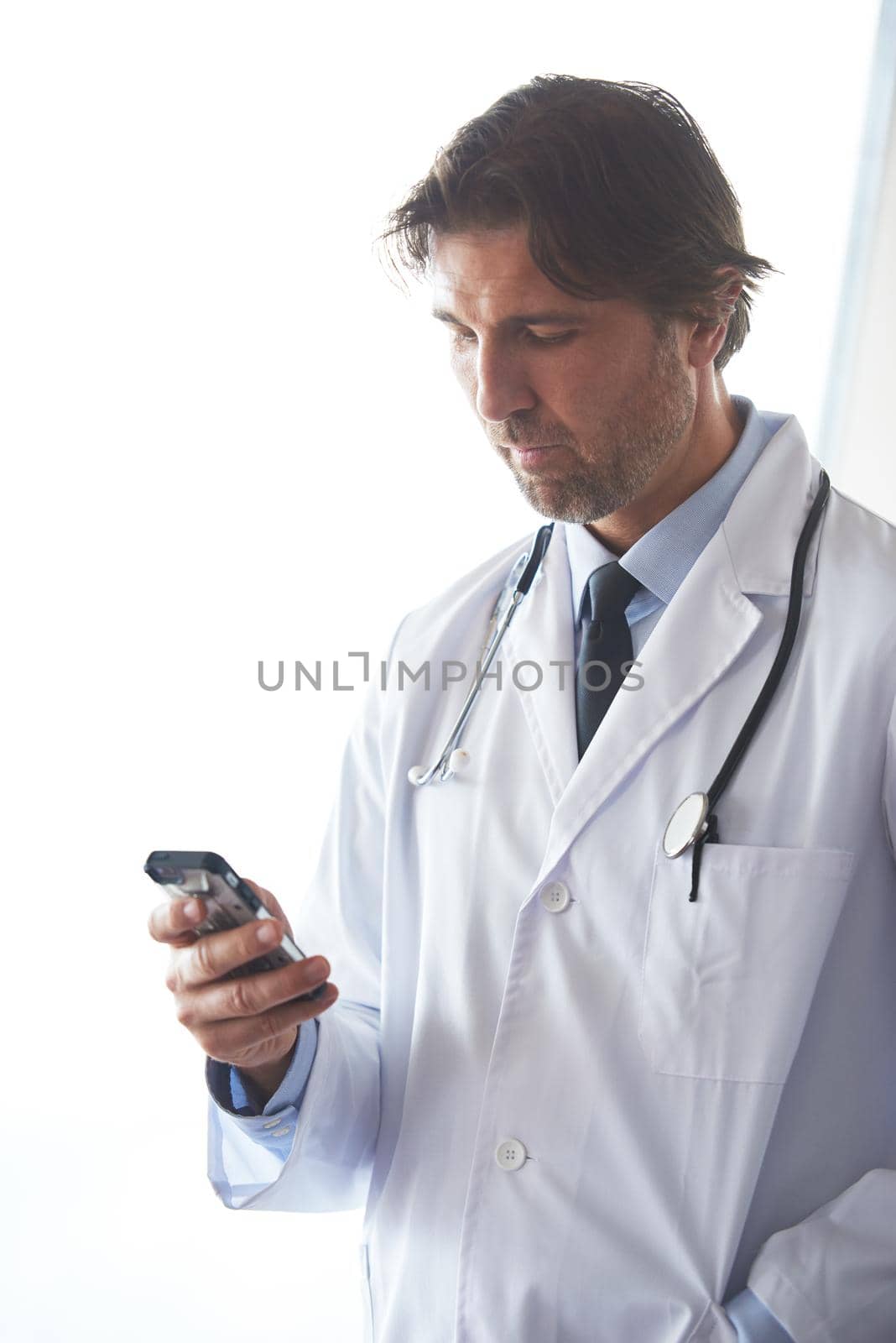 handsome doctor speaking on cellphone at modern hospital indoors