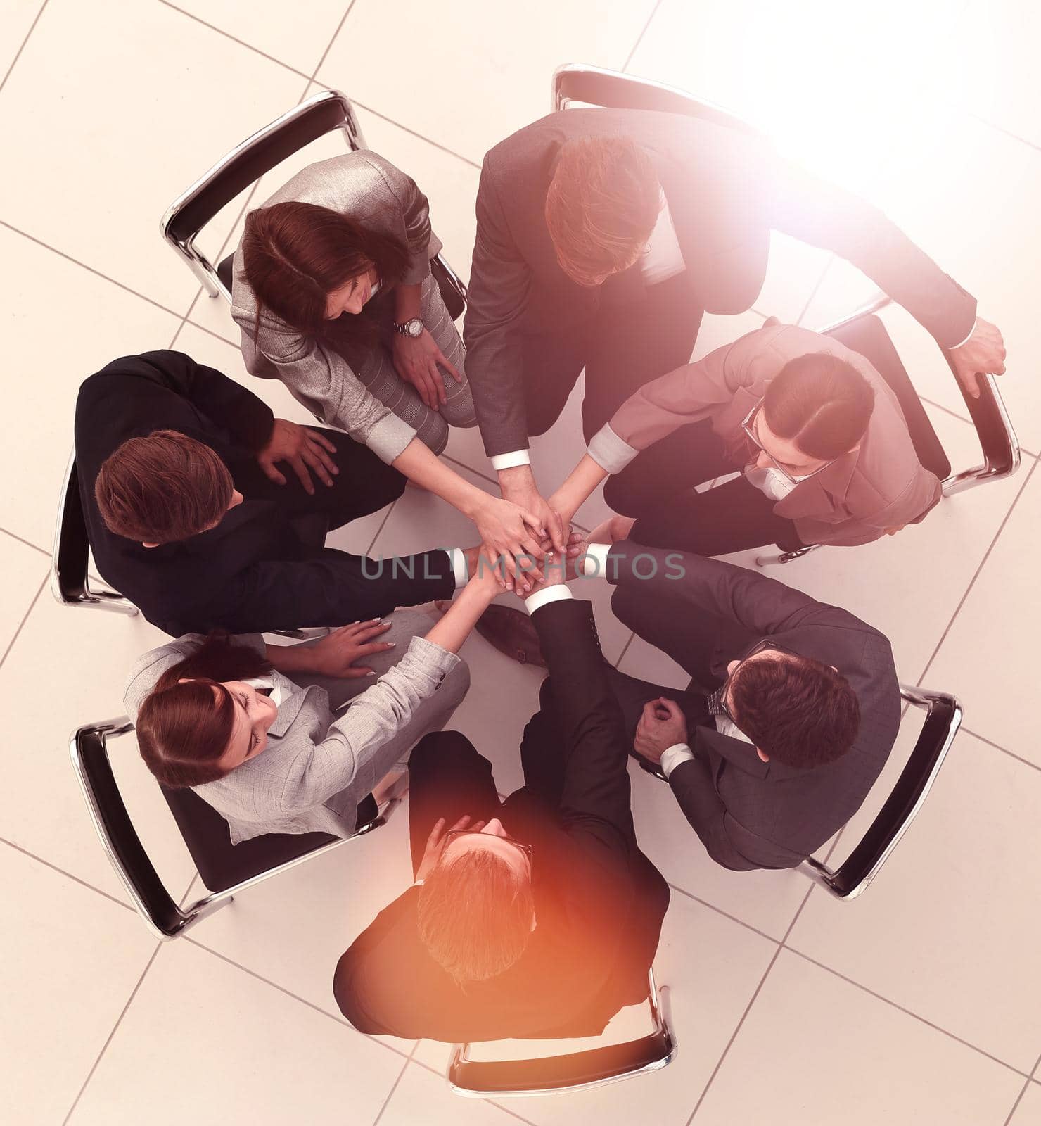 top view.a group of employees with their hands folded together by asdf