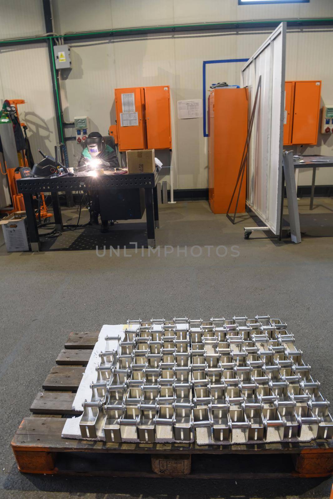 The first phase of metal and aluminum processing. Processed products from CNC machines stacked on a pallet in a large modern factory. High quality photo